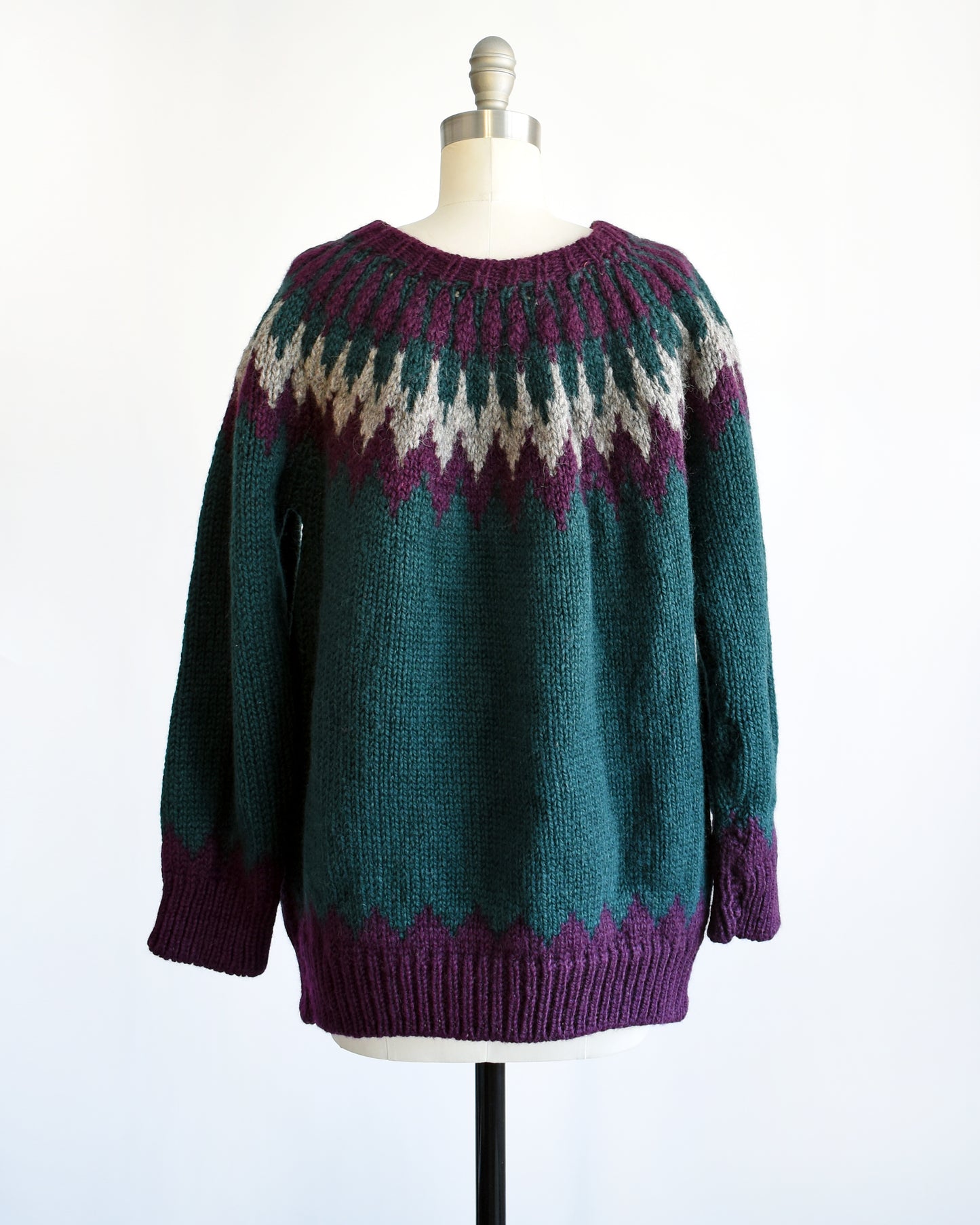 Back view of a vintage 1970s dark teal wool Nordic sweater with a purple and gray Fair Isle pattern around the collar. Complimentary purple pattern on the hem and cuffs.