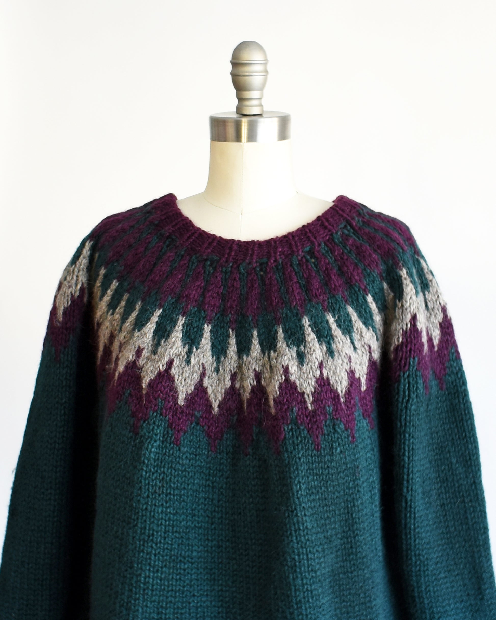 Close up of the a vintage 1970s dark teal wool Nordic sweater with a purple and gray Fair Isle pattern around the collar