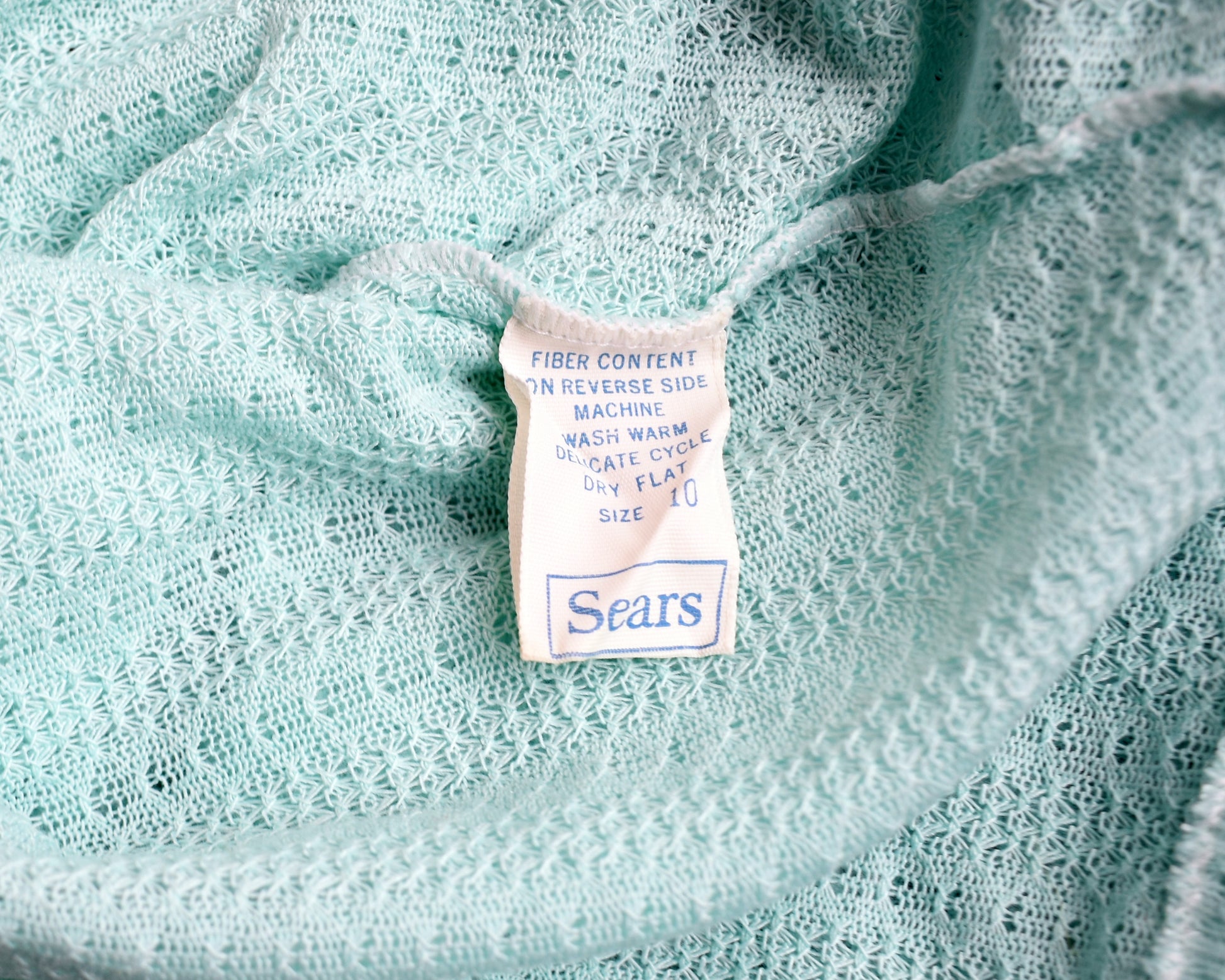 Close up of the tag on the bed jacket which says Sears