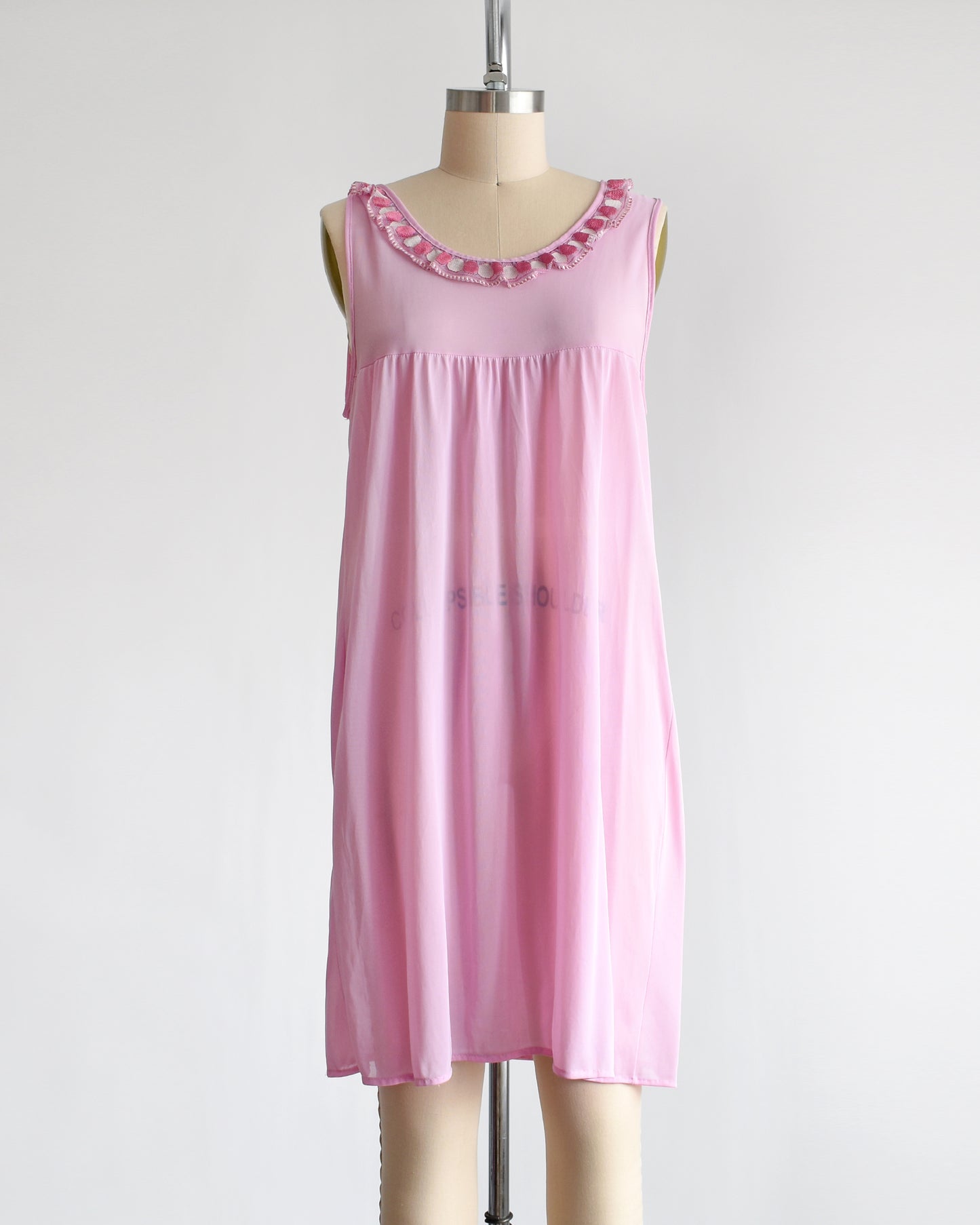 A vintage late 1960s early 1970s pinky purple nightgown with embroidered ruffle trim under the neckline