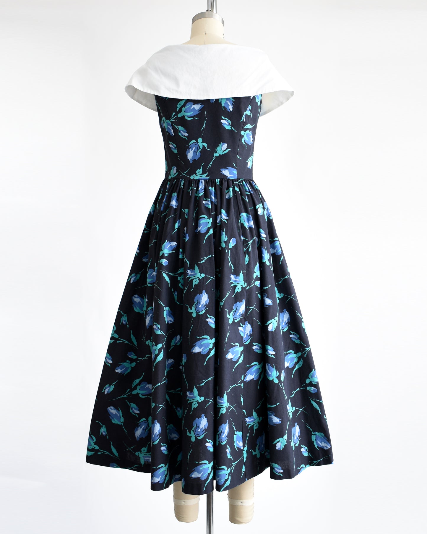 back view of a vintage 1980s Laura Ashley dress that has a black and blue floral pattern and large white shawl collar.