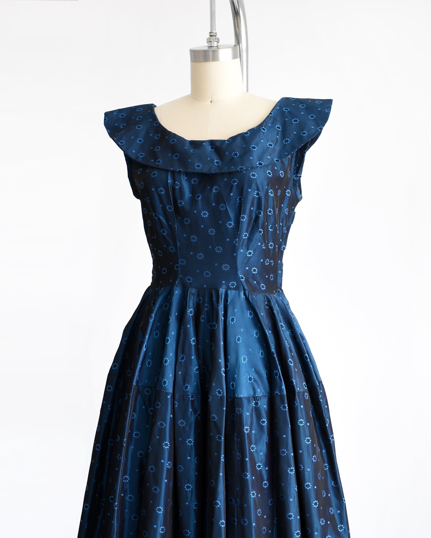 side front view of a vintage 1950s blue black floral brocade dress