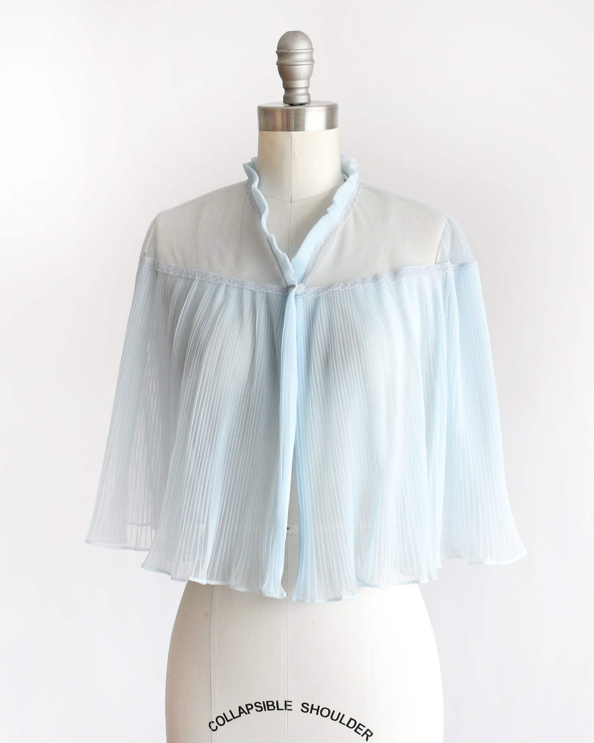 side front view of a vintage 1960s light blue pleated bed jacket
