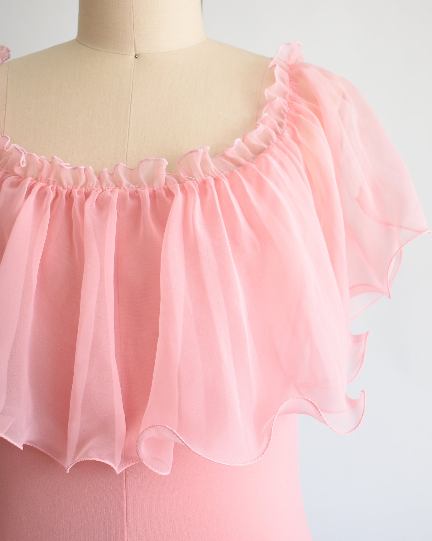 close up of the bodice of a vintage 1970s pink flutter maxi dress