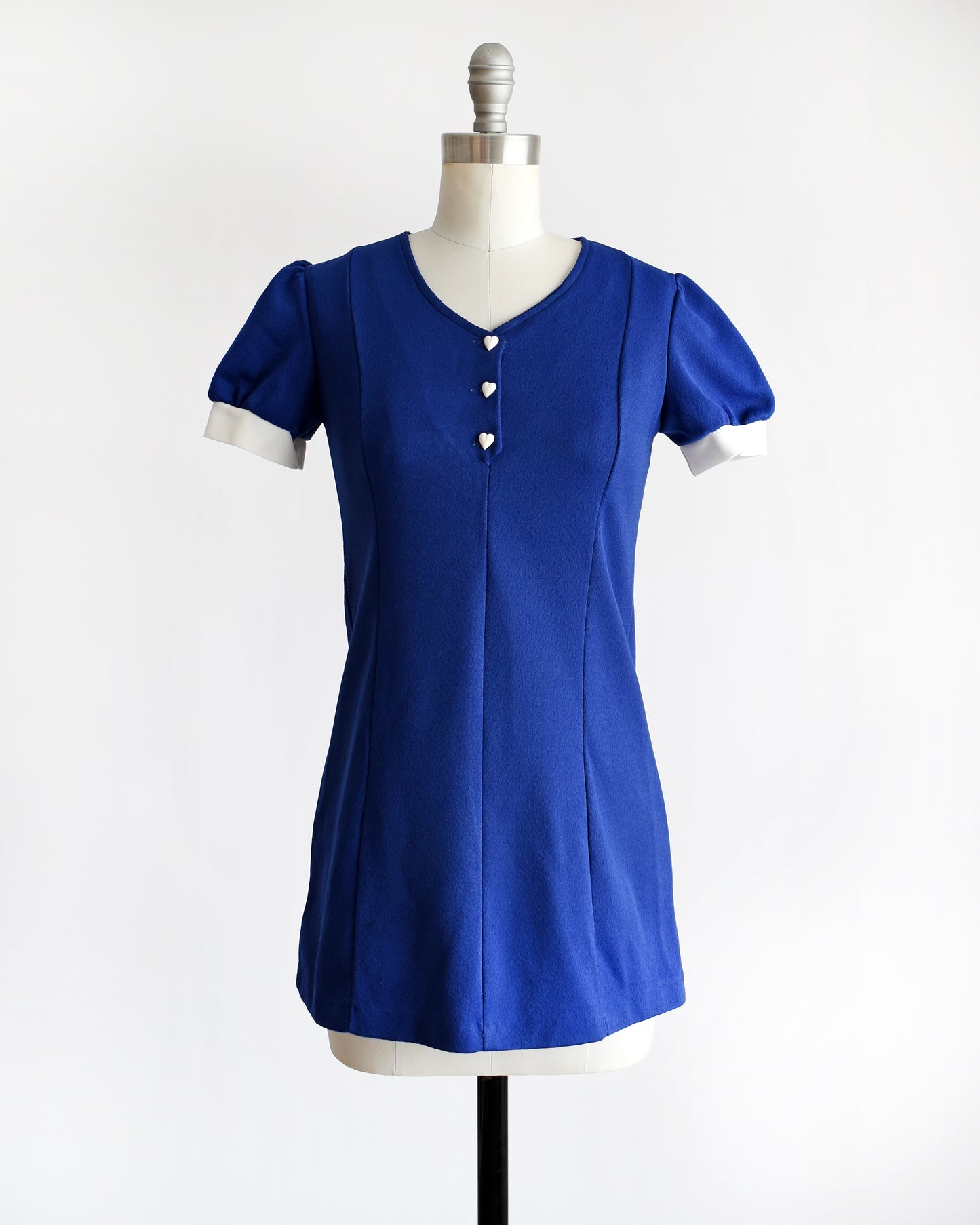 a vintage late 1960s early 1970s dark blue top with three white heart buttons under the neckline.