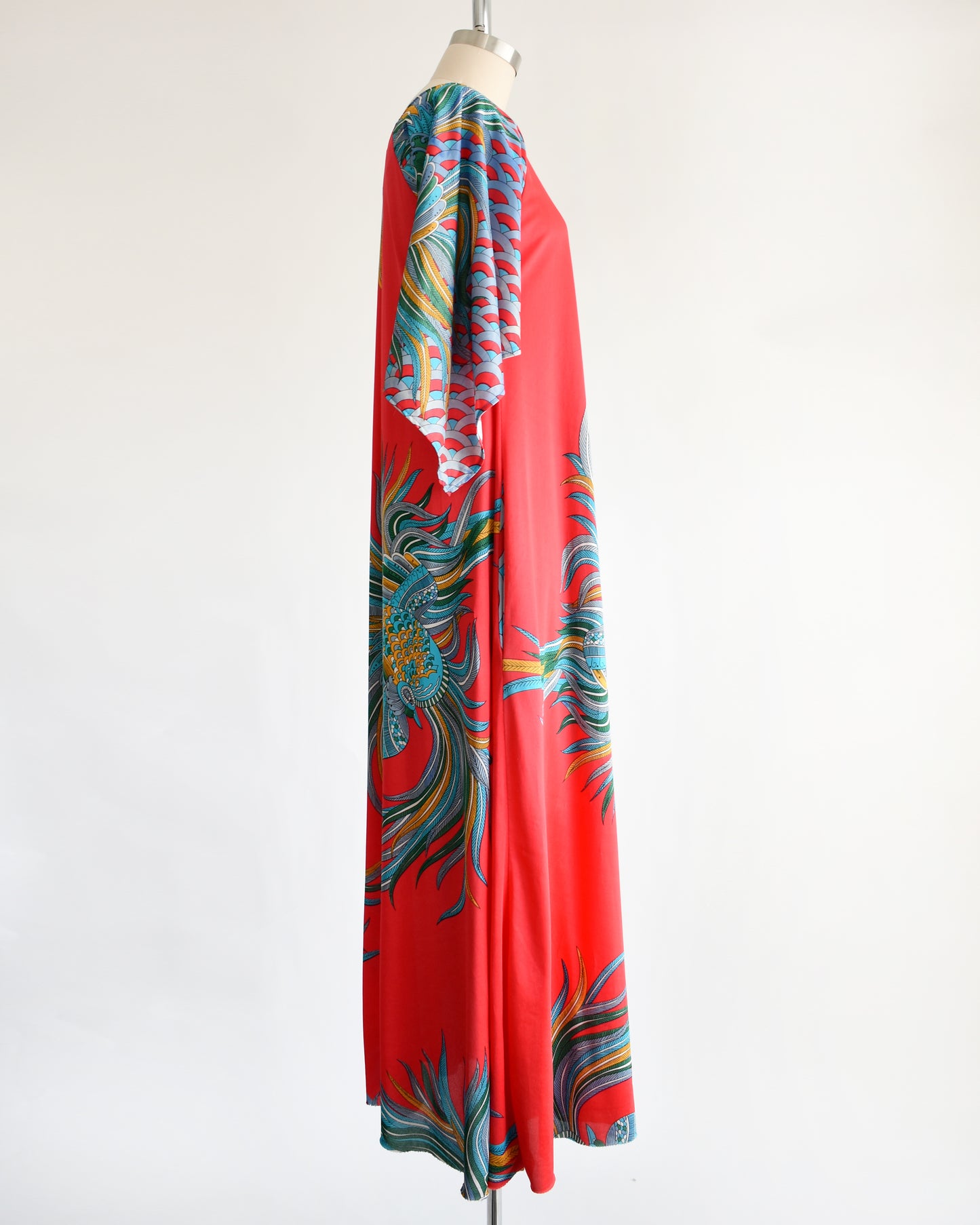 side view of a vintage 1970s red and blue psychedelic bird caftan
