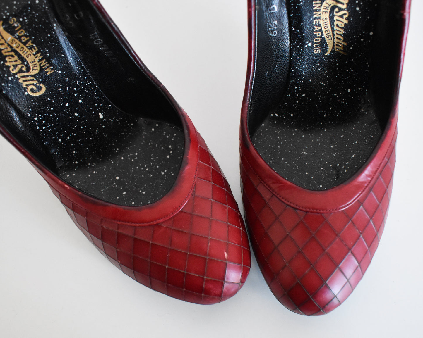 Close up of the toes of a pair of vintage 1960s burgundy criss-cross pattern high heels