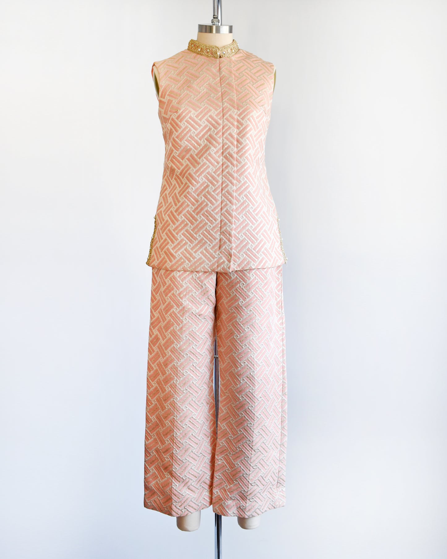 A vintage 1960s pink and gold mod pant set with a metallic gold collar with rhinestone trim. The set includes a matching top and bottoms.