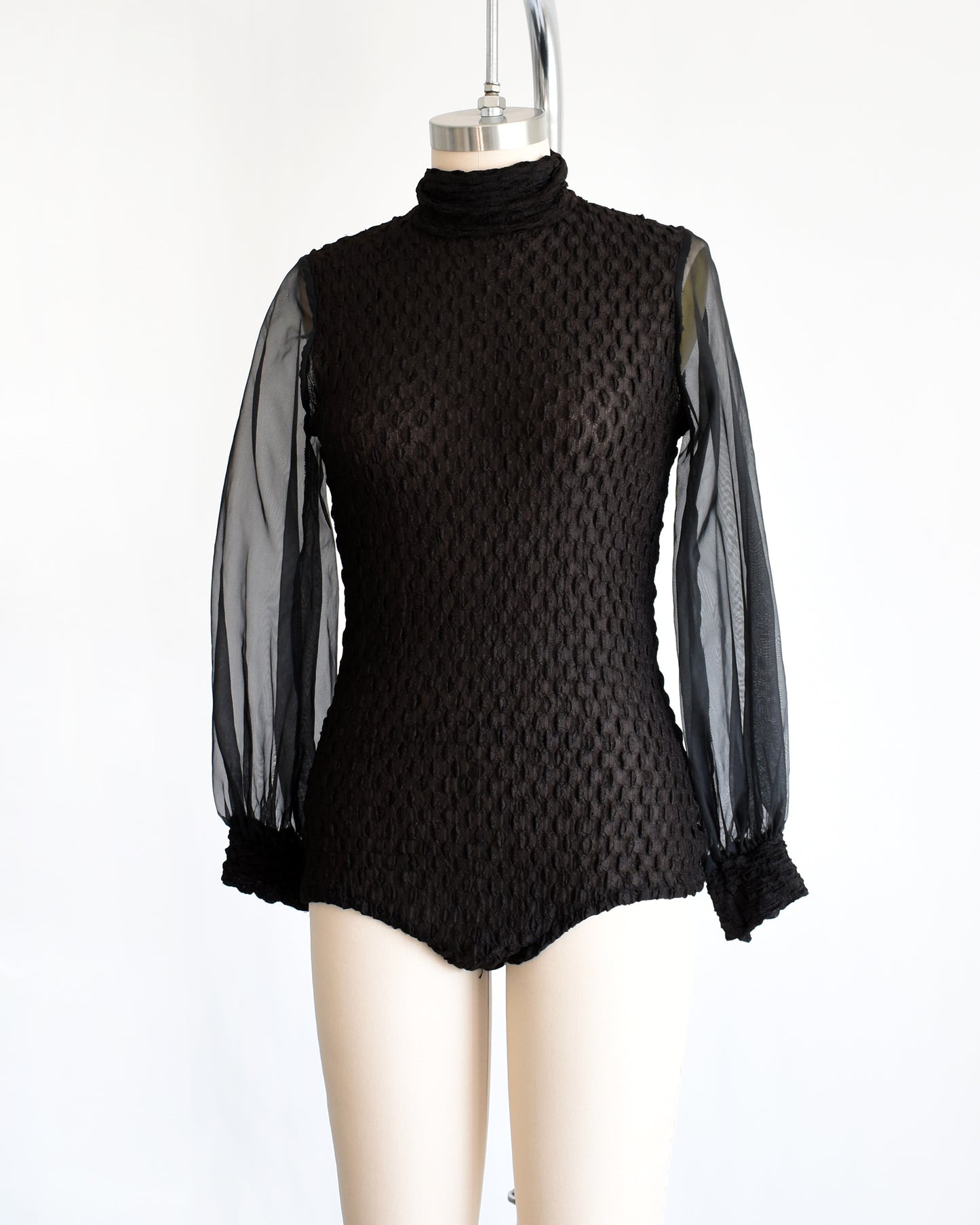side front view of a vintage 1970s black textured bodysuit with long sleeves