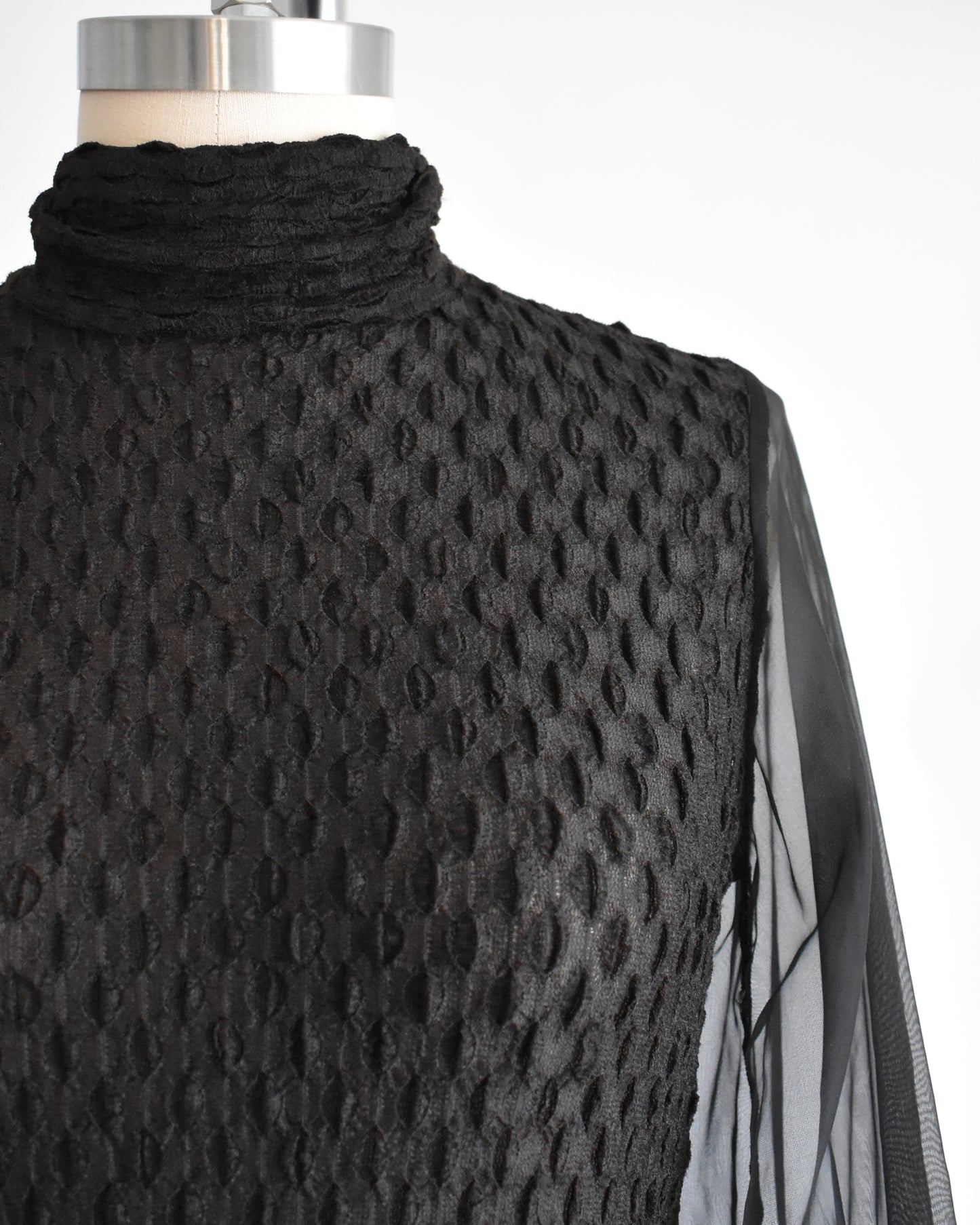 close up of the bodice of a vintage 1970s black textured bodysuit with long sleeves