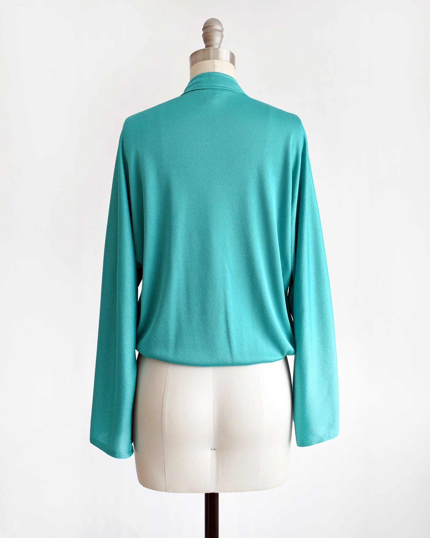back view of a vintage 1970s teal bell sleeve blouse