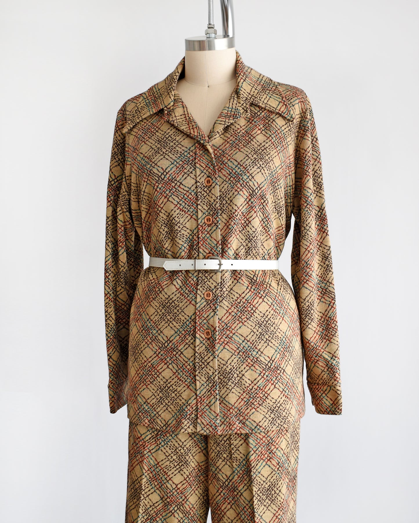 Side front view of a vintage 1970s brown plaid pant set with a decorative white belt