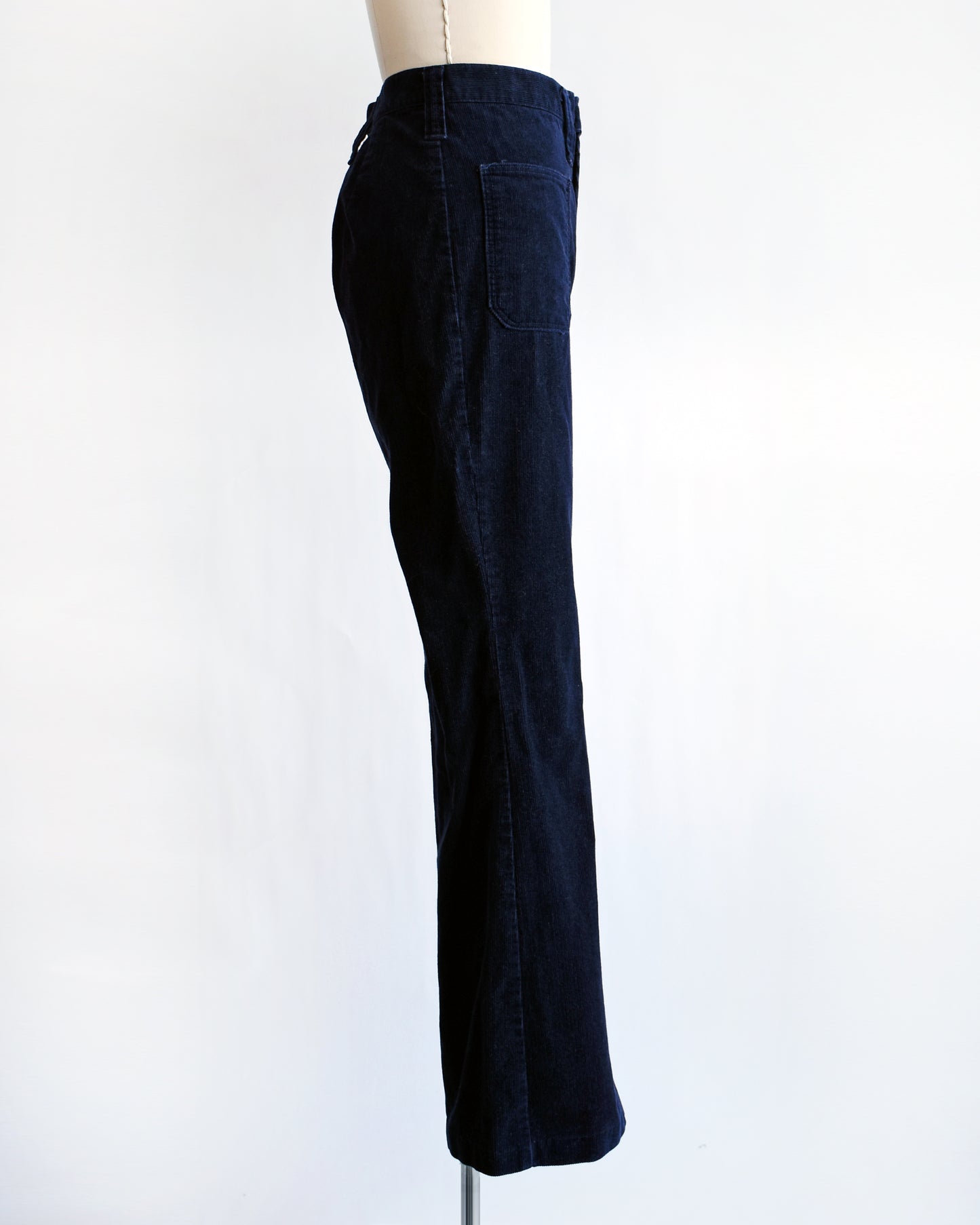 side view of a pair of vintage 1970s navy blue corduroy bell bottoms by Lady Wrangler