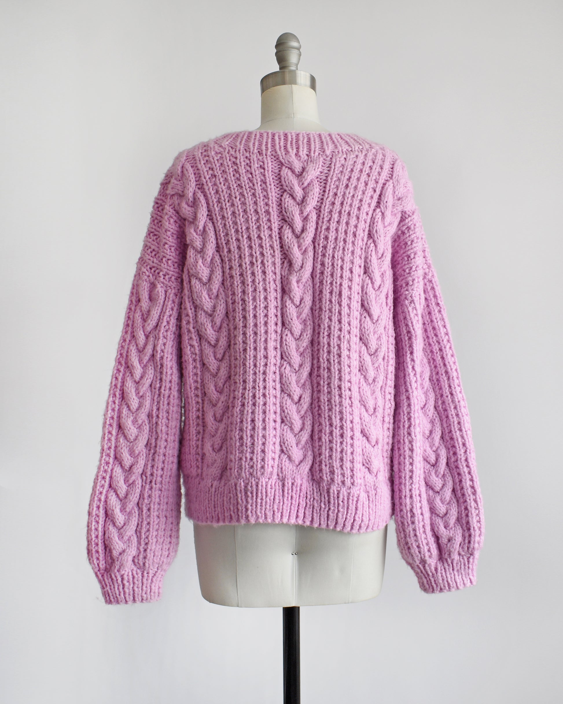 back view of a vintage 1980s chunky purple pink cable knit sweater