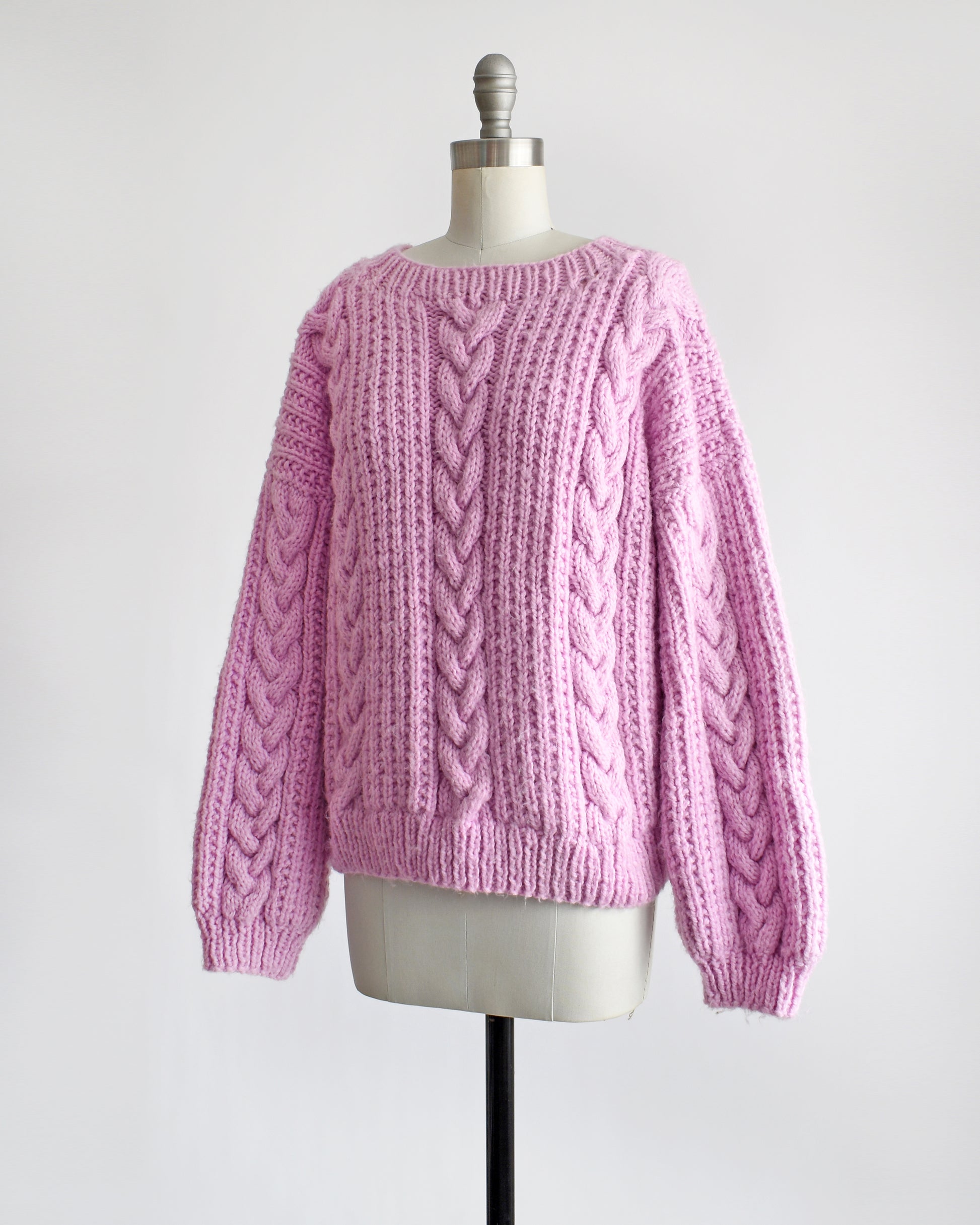 side front view of a vintage 1980s chunky purple pink cable knit sweater