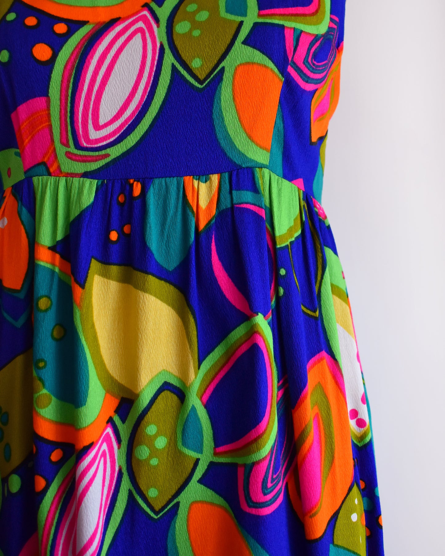 close up of the waist and skirt of a vintage 1970s psychedelic maxi dress