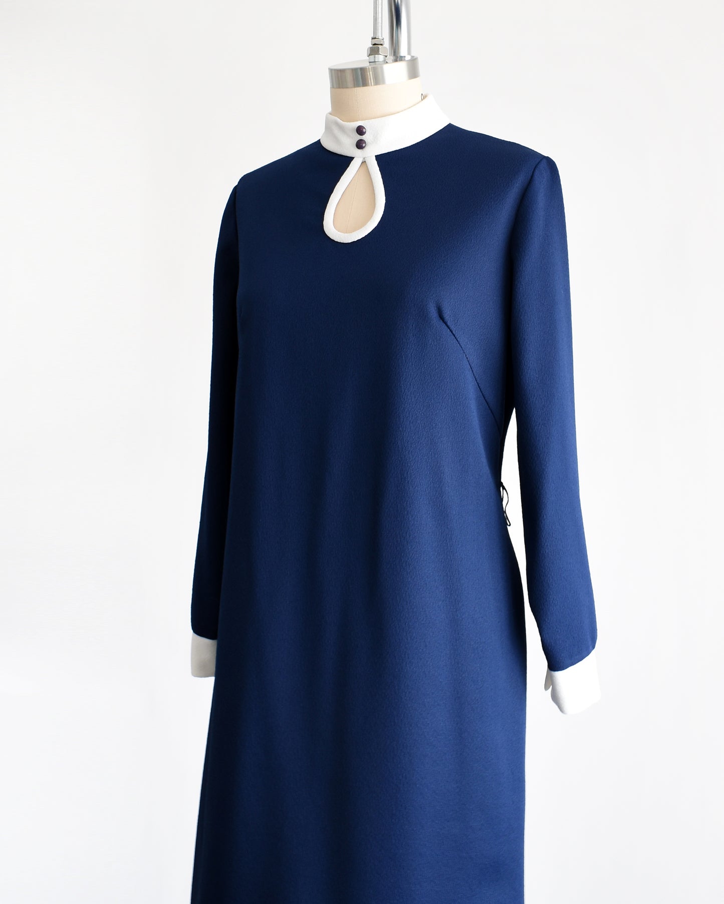 Side front view of a  late 1960s to early 1970s mod two piece set features a navy blue long sleeve dress