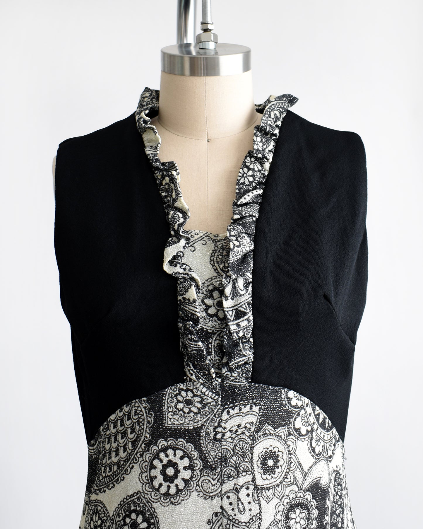 Close up of the bodice of the dress which hows the ruffled floral paisley print neckline.