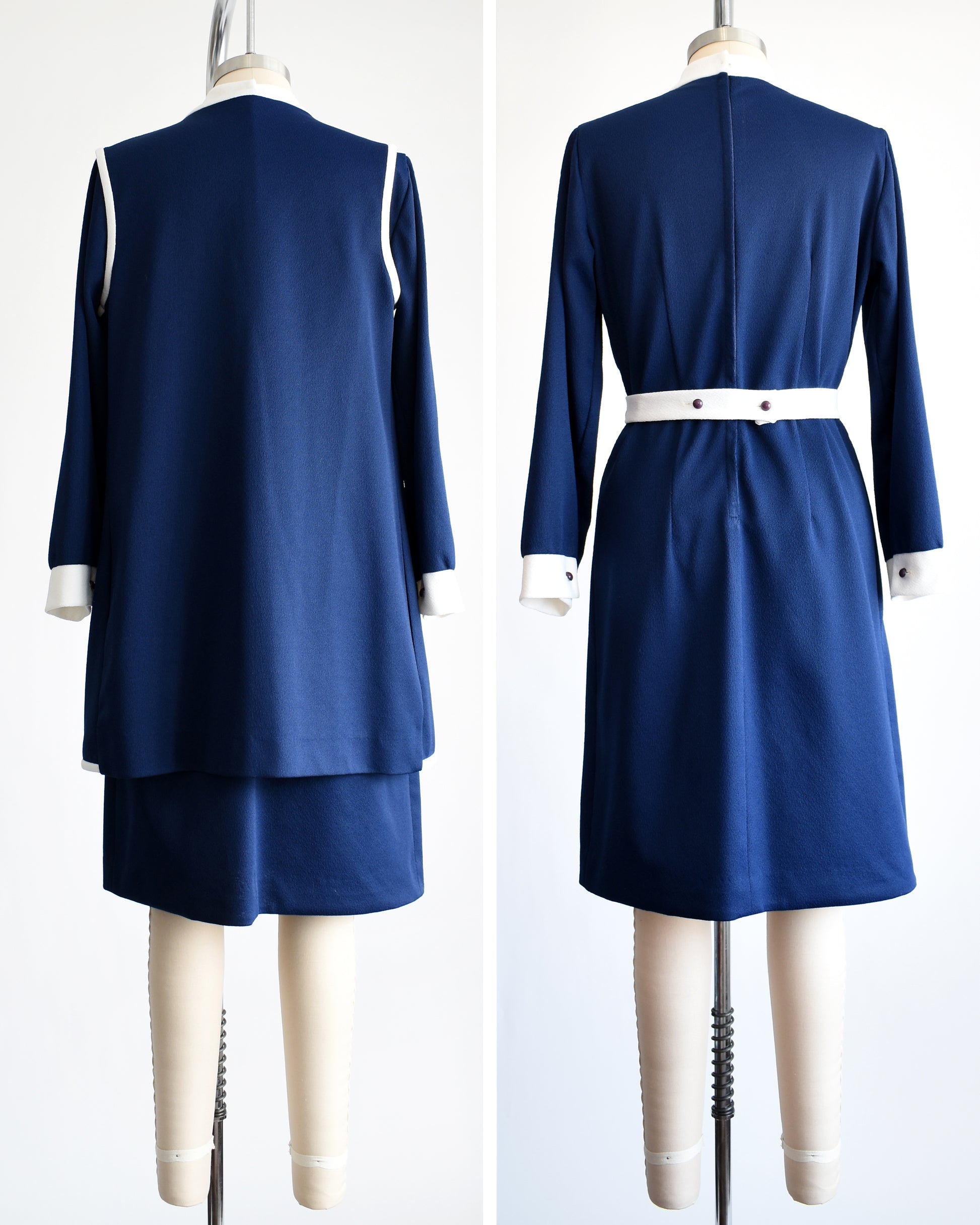 Side by side view of the back of a  late 1960s to early 1970s mod two piece set features a navy blue long sleeve dress and matching vest and white belt.