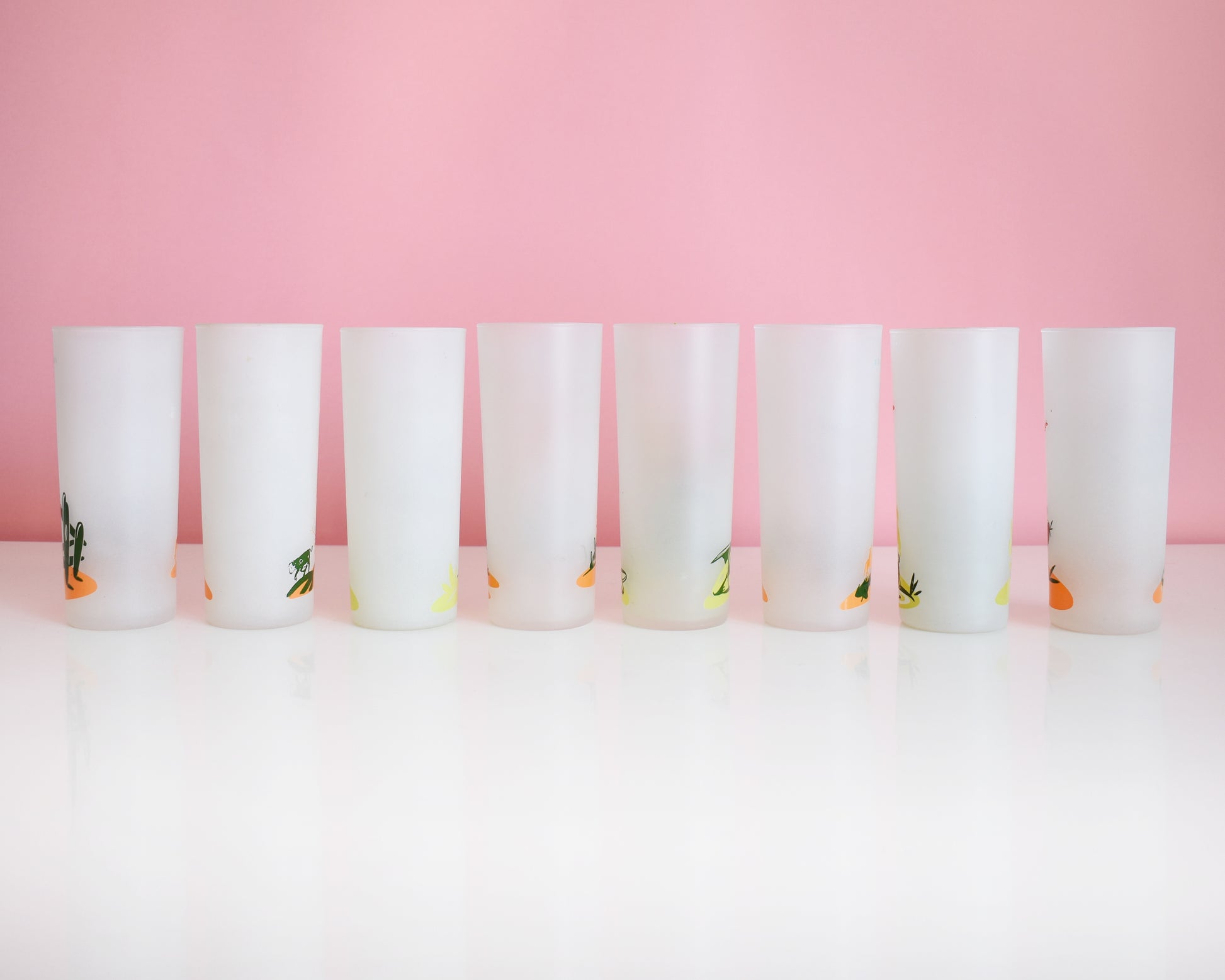 Back view of a set of 8 vintage glasses that each have a cactus or plant that is native to Arizona