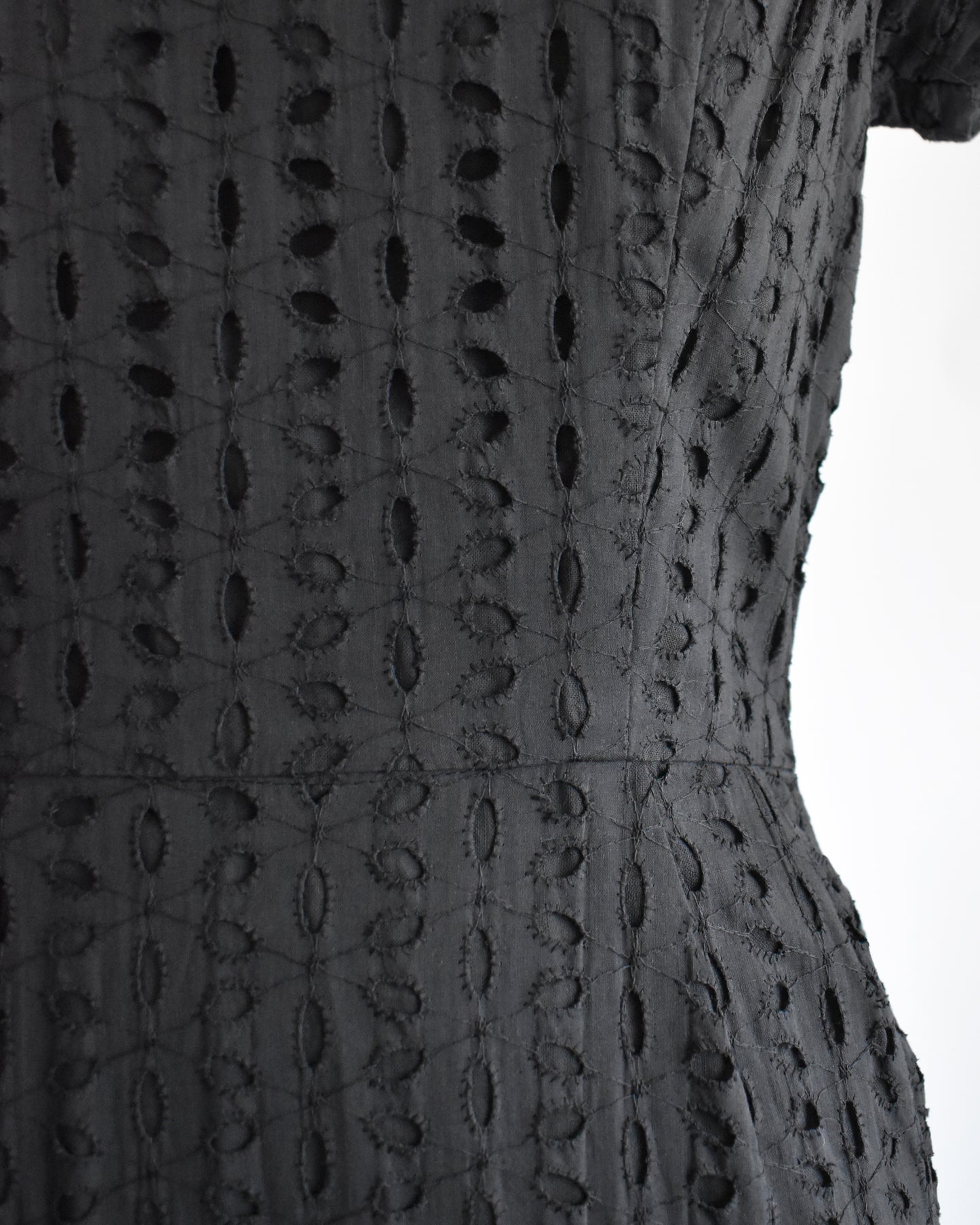 close up of the waist of a vintage 1960s black eyelet dress