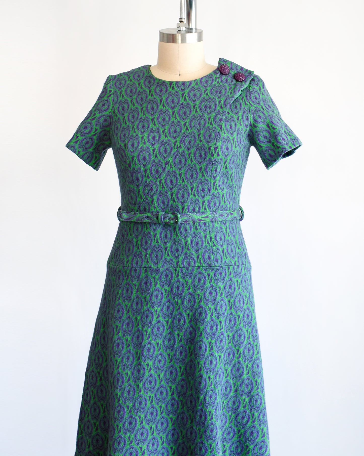 side front view of a vintage 1960s green and purple drop waist dress and matching belt