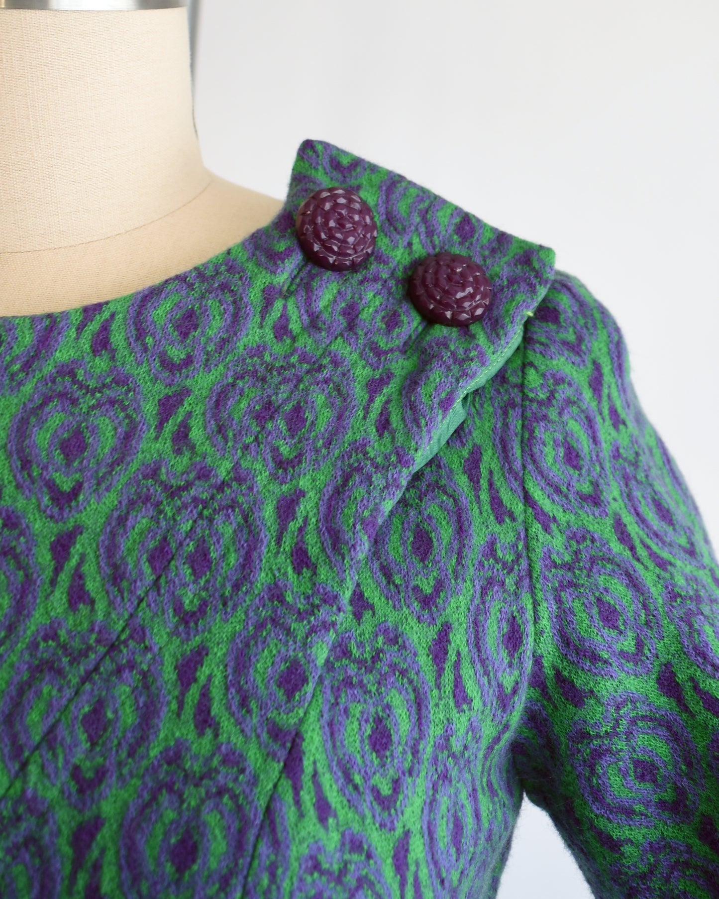 close up of the decorative purple buttons on the left shoulder