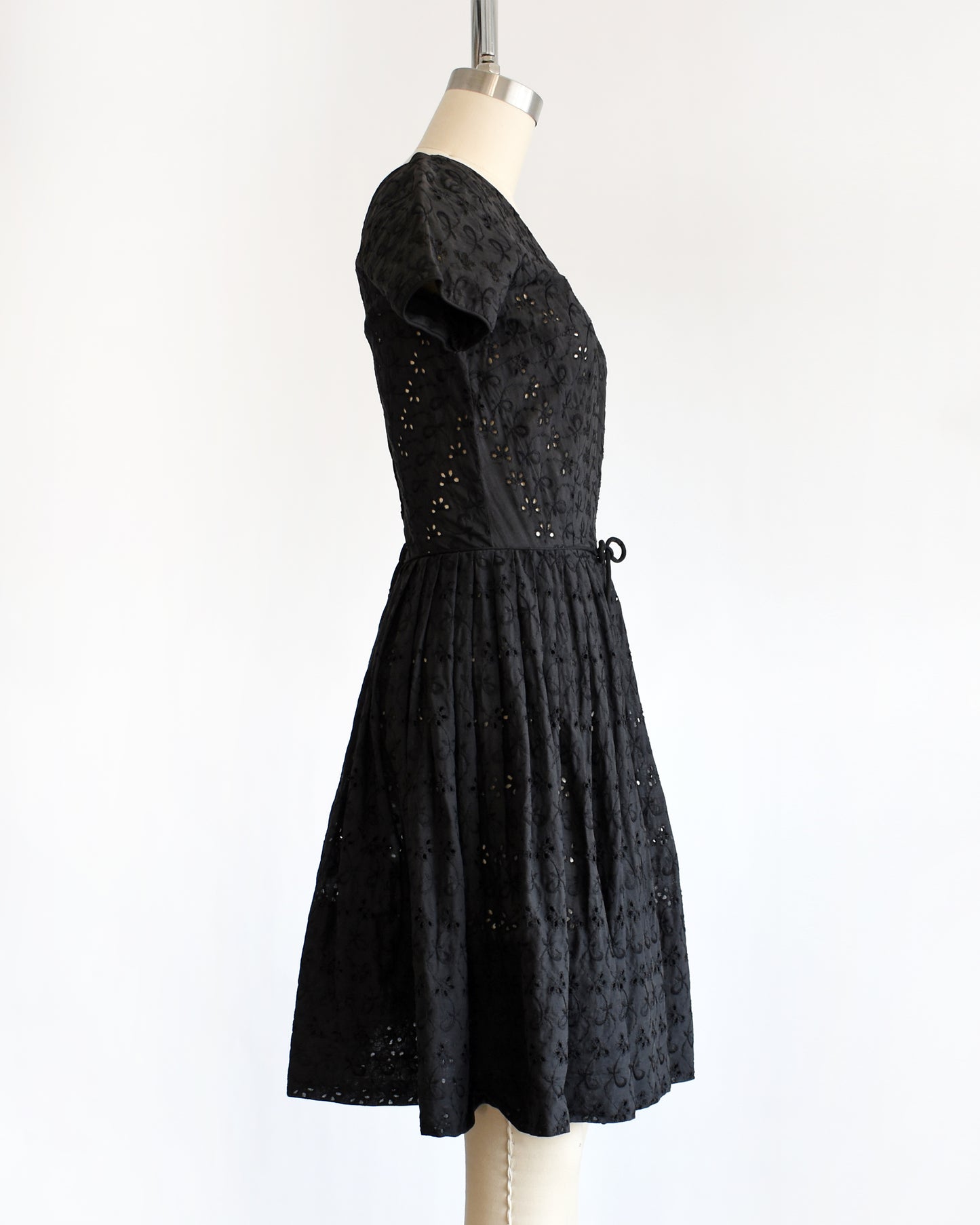 side view of a late 1950s early 1960s vintage black eyelet dress