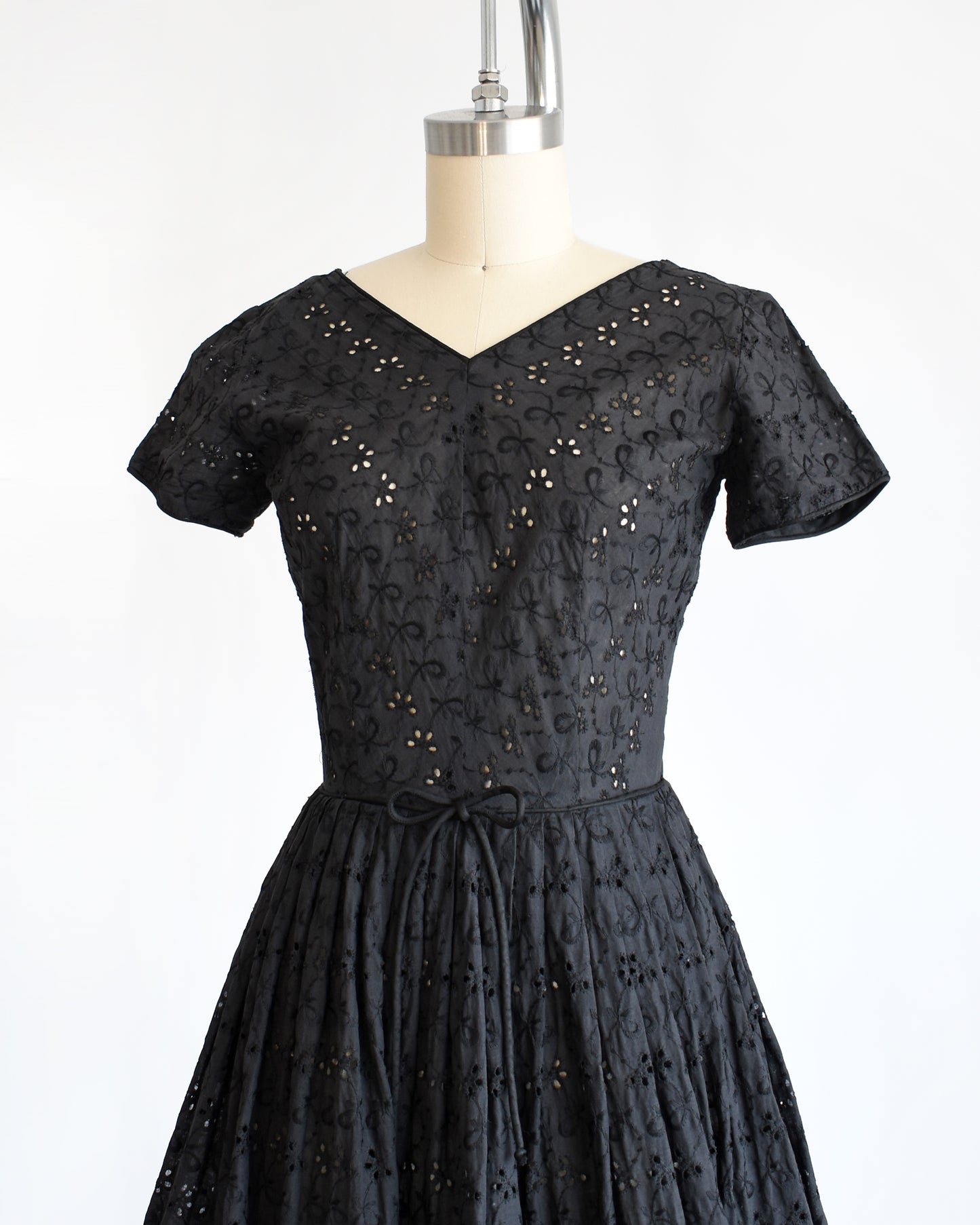 side font view of a late 1950s early 1960s vintage black eyelet dress