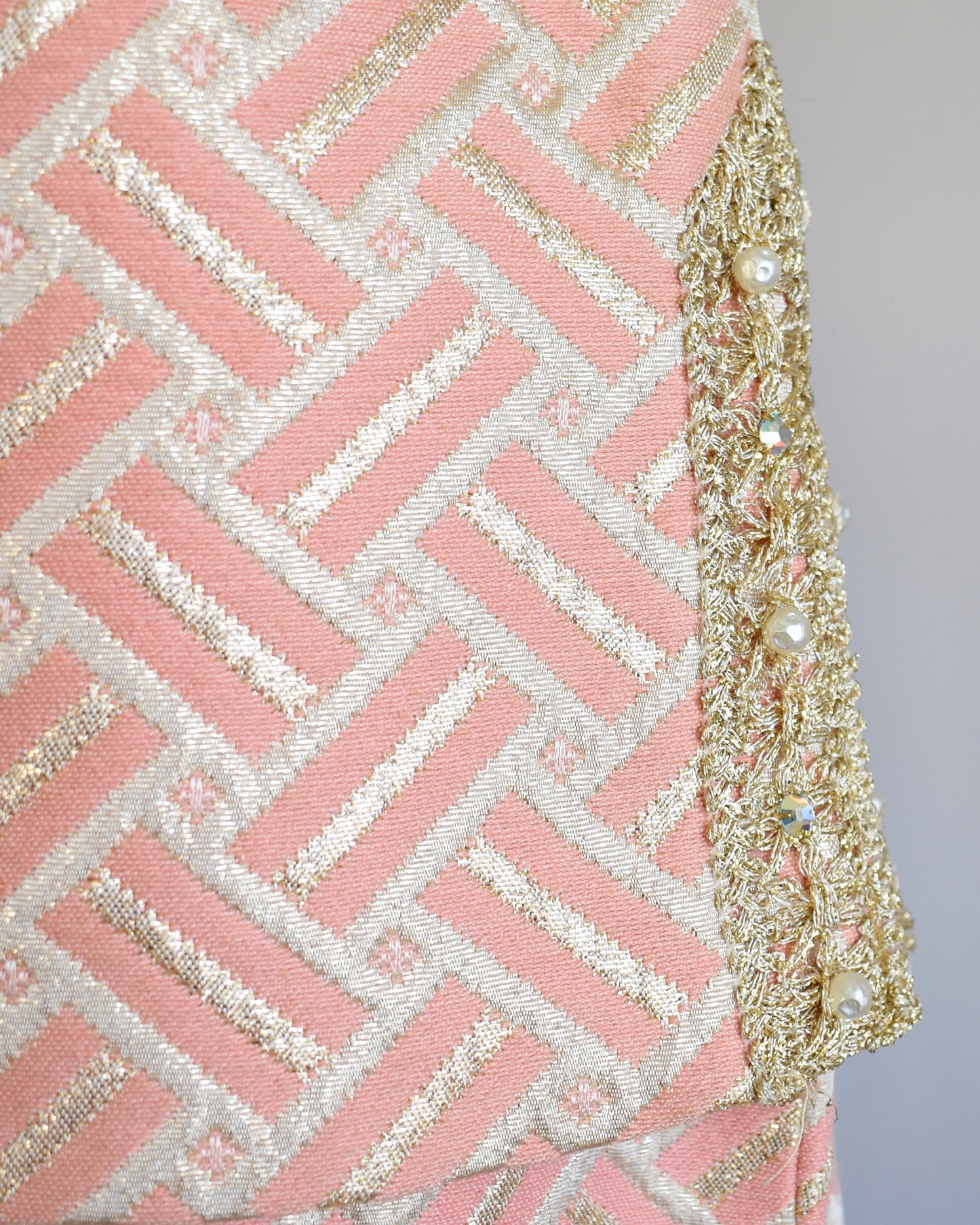 Close up of the metallic brocade and metallic gold trim with rhinestones on the side