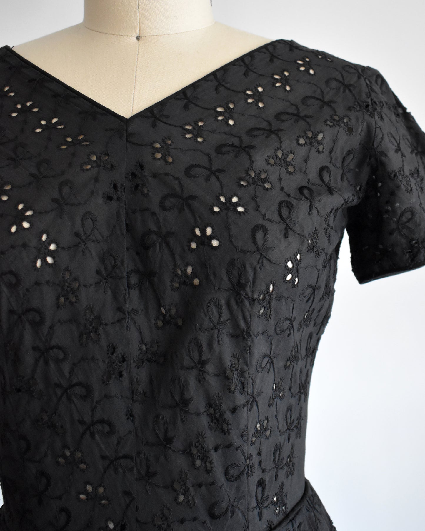 close up of the bodice of a late 1950s early 1960s vintage black eyelet dress
