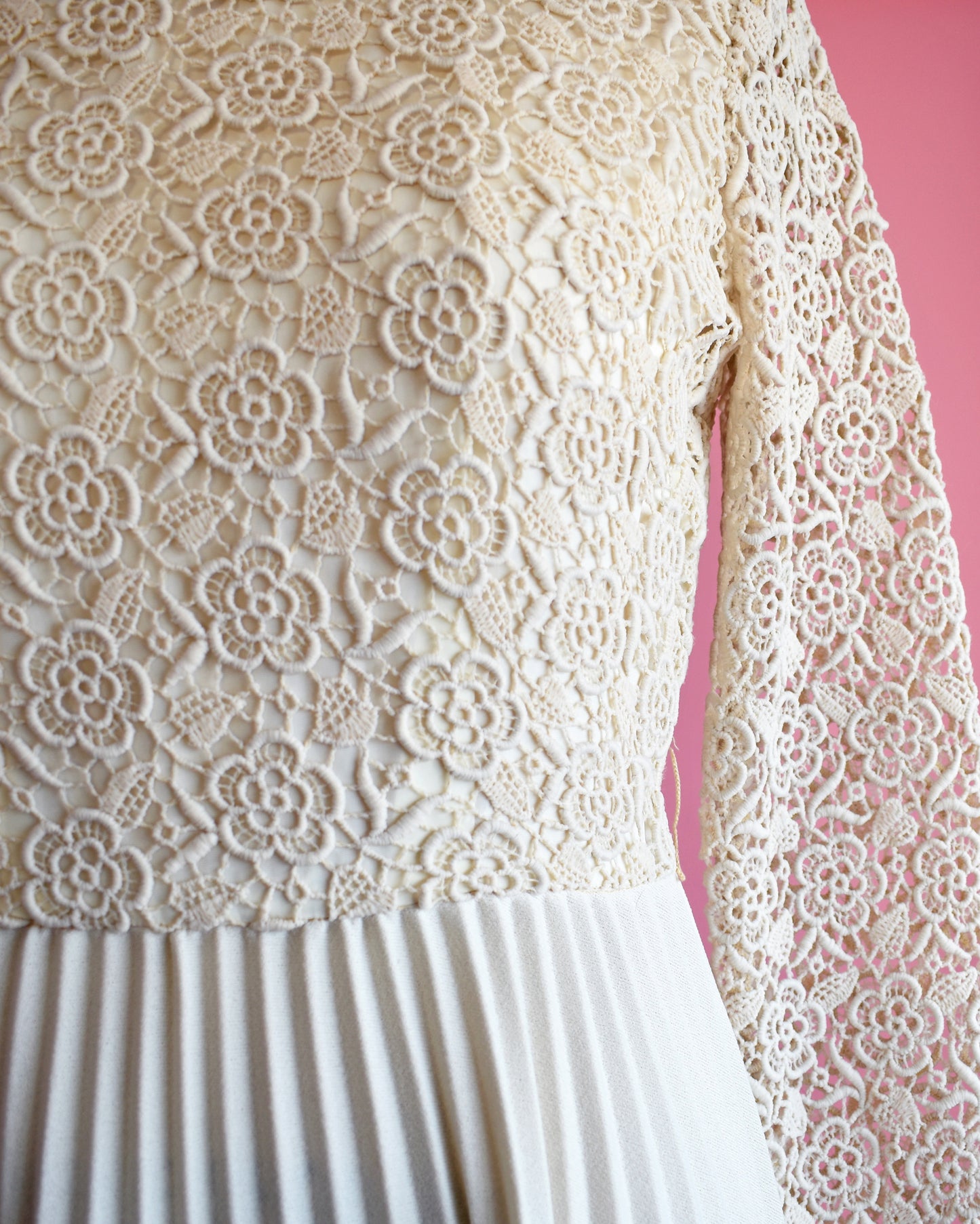 close up of the floral lace bodice, waistline, and pleated skirt
