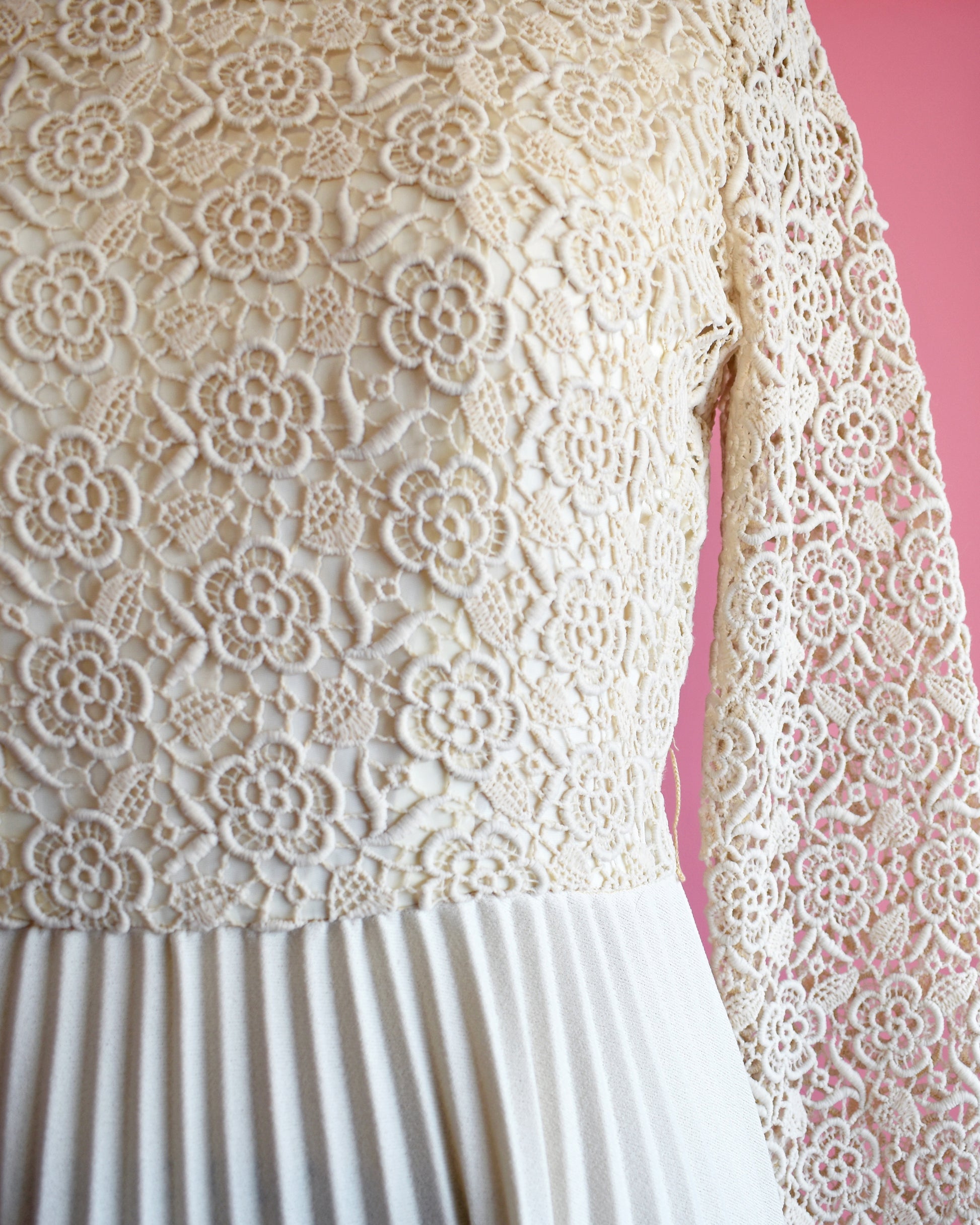 close up of the floral lace bodice, waistline, and pleated skirt