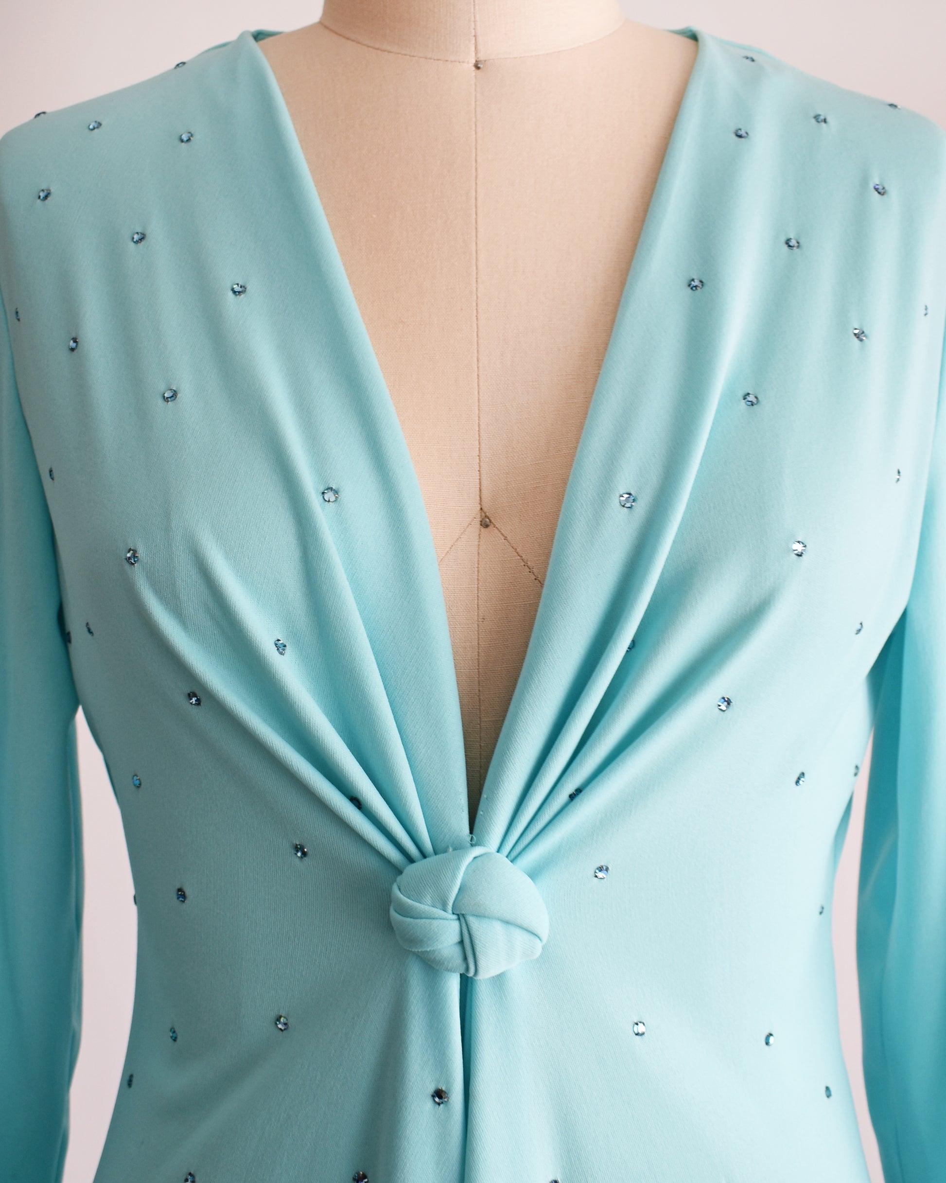 close up of the plunging neckline, rhinestones, and decorative knot