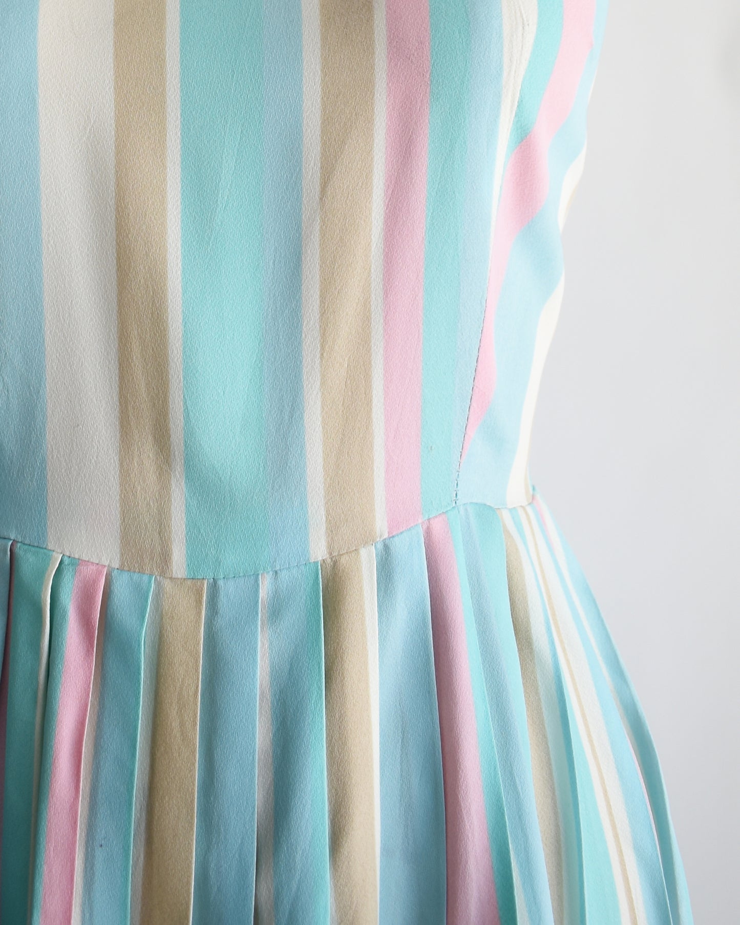 close up of the waist on a vintage 1960s striped pastel rainbow dress