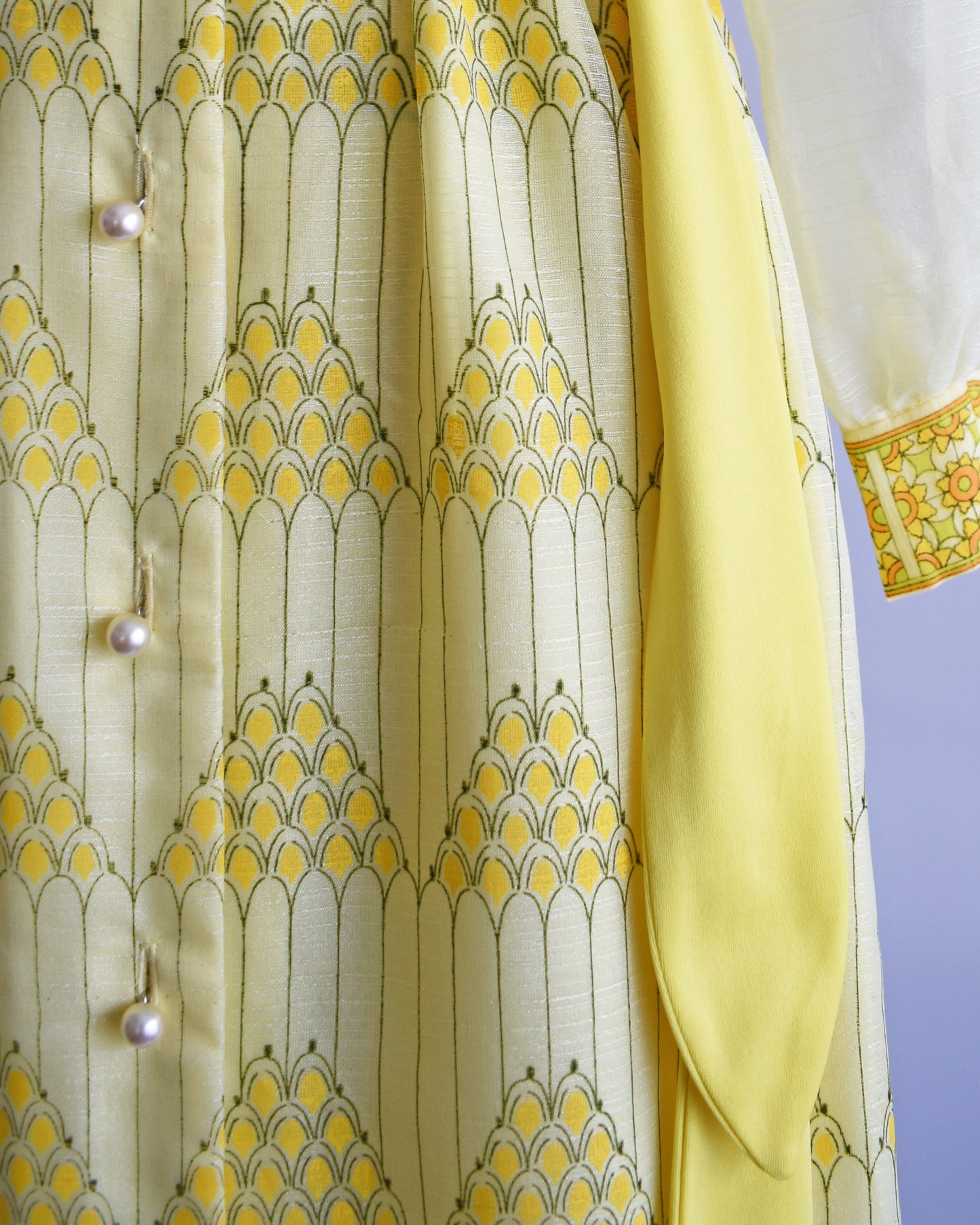 Close up of the pyramid print and buttons on the skirt and yellow sash