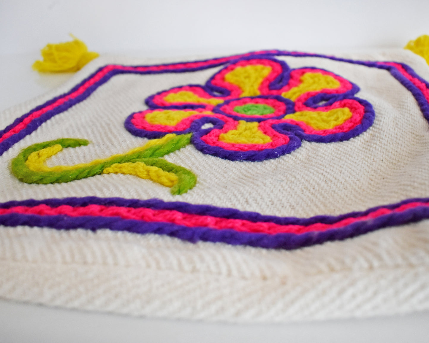 Close up of the floral pillow, showing the textured detail and embroidery