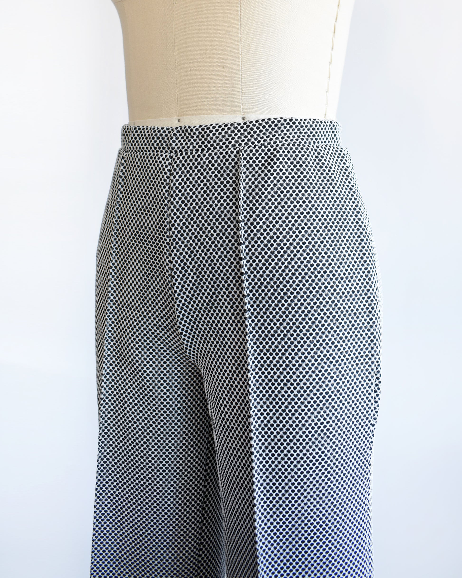 close up of the waist and hips of  a vintage 1970s black and white polka dot wide leg pants. 