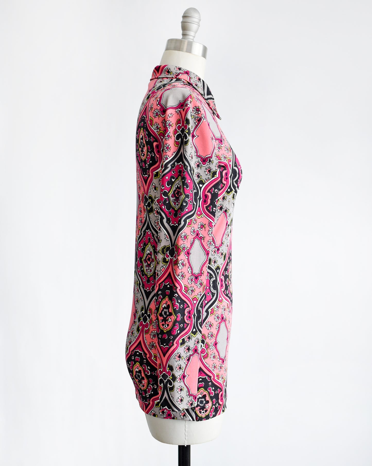 side view of a vintage 1970s pink and black psychedelic floral blouse.