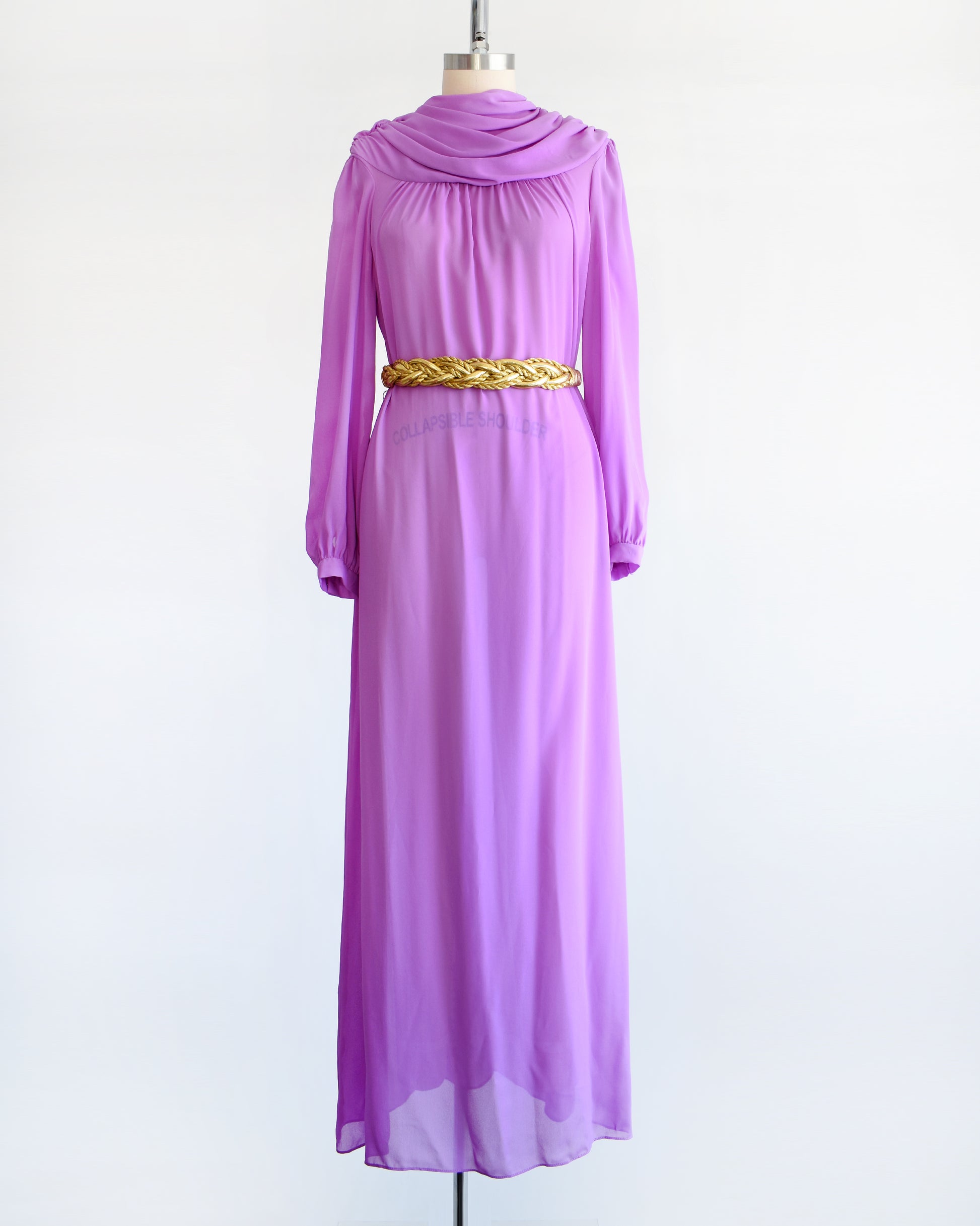 A vintage 1970s purple semi sheer maxi dress by Joy Stevens California that has a draped neckline and long sleeves and a gold belt that is just for show and not included