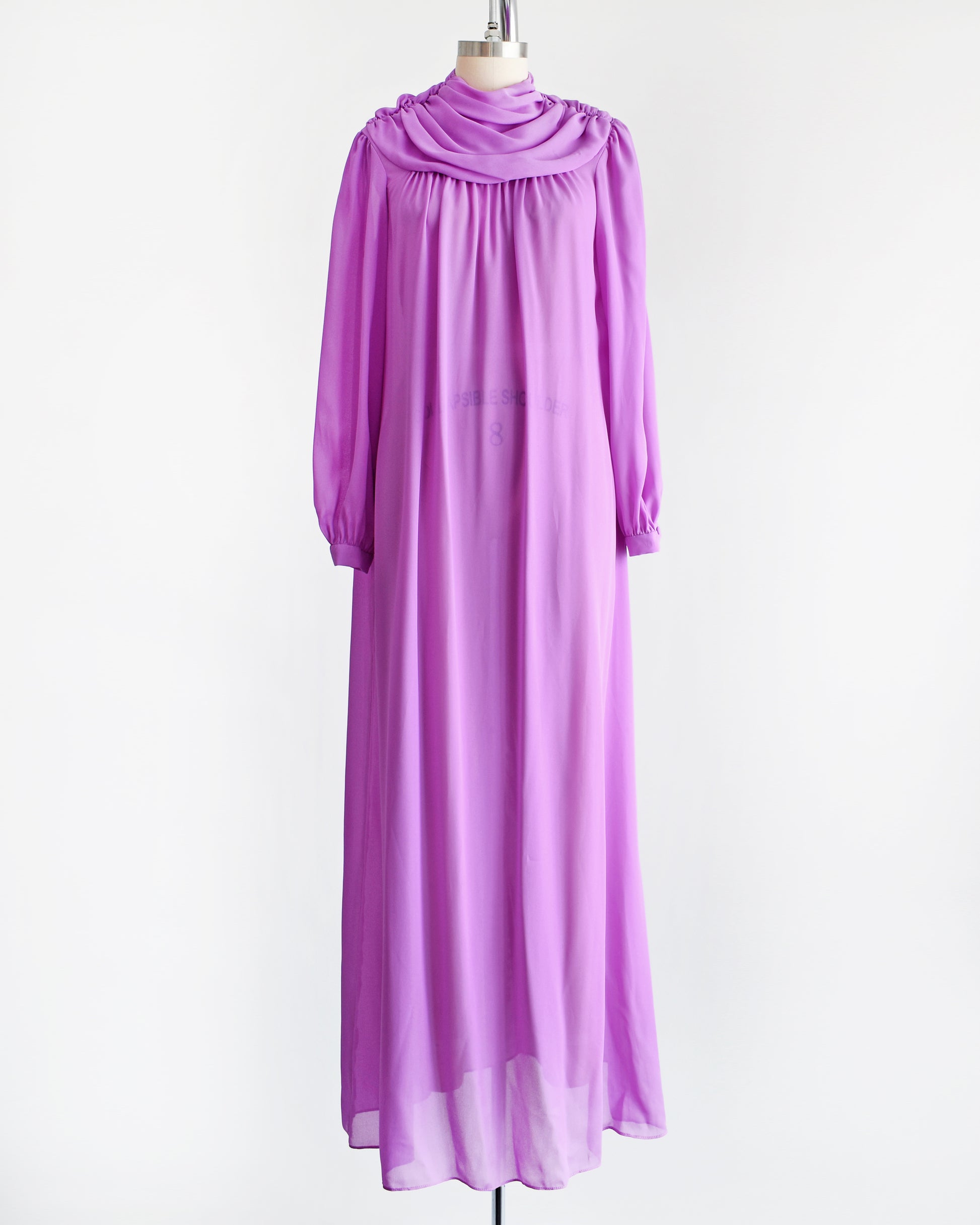A vintage 1970s purple semi sheer maxi dress by Joy Stevens California that has a draped neckline and long sleeves
