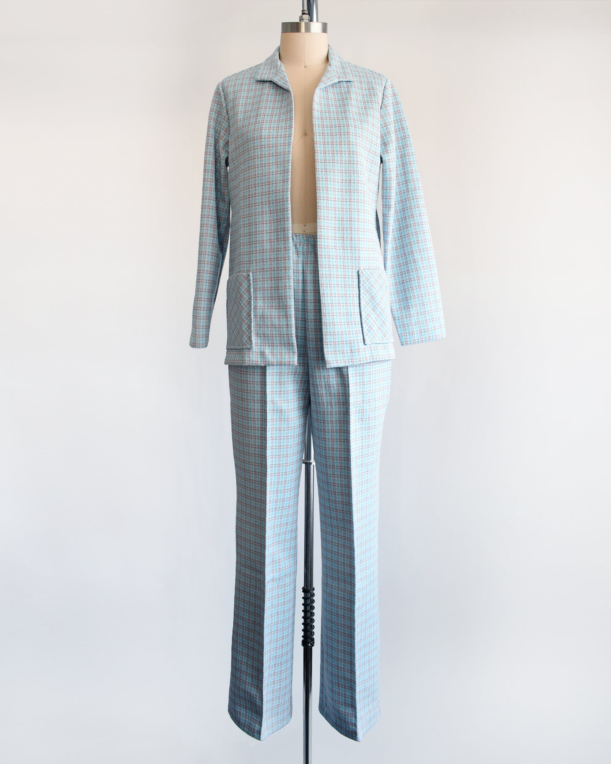 A  vintage 1970s blue, white, and orange plaid pantsuit. This set includes a blazer and matching wide leg pants.