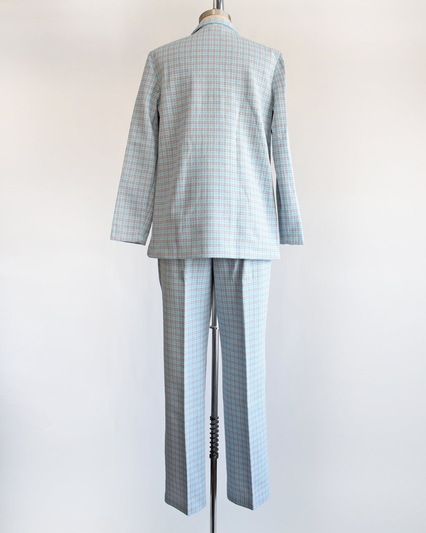 Back view of a  vintage 1970s blue, white, and orange plaid pantsuit. This set includes a blazer and matching wide leg pants.