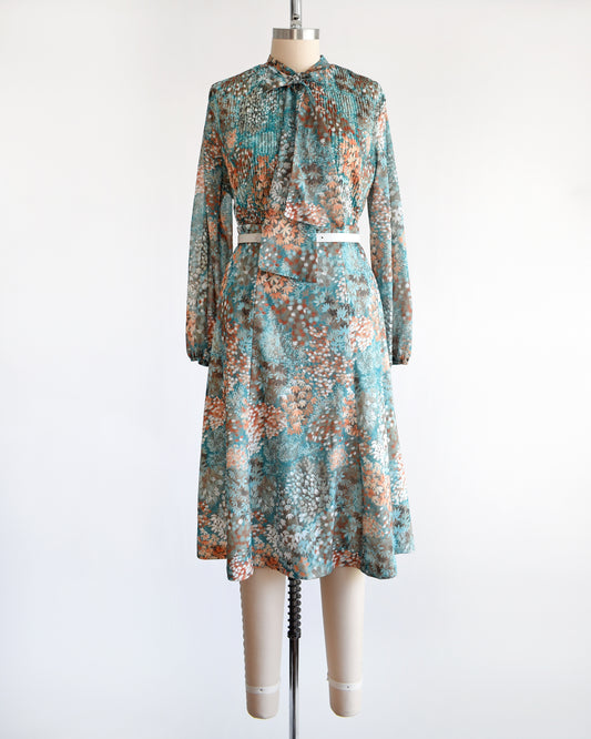 A vintage 1970s floral blue and orange floral dress set. This set comes with a matching blouse and skirt.  The set is modeled with a white belt, which isn't included