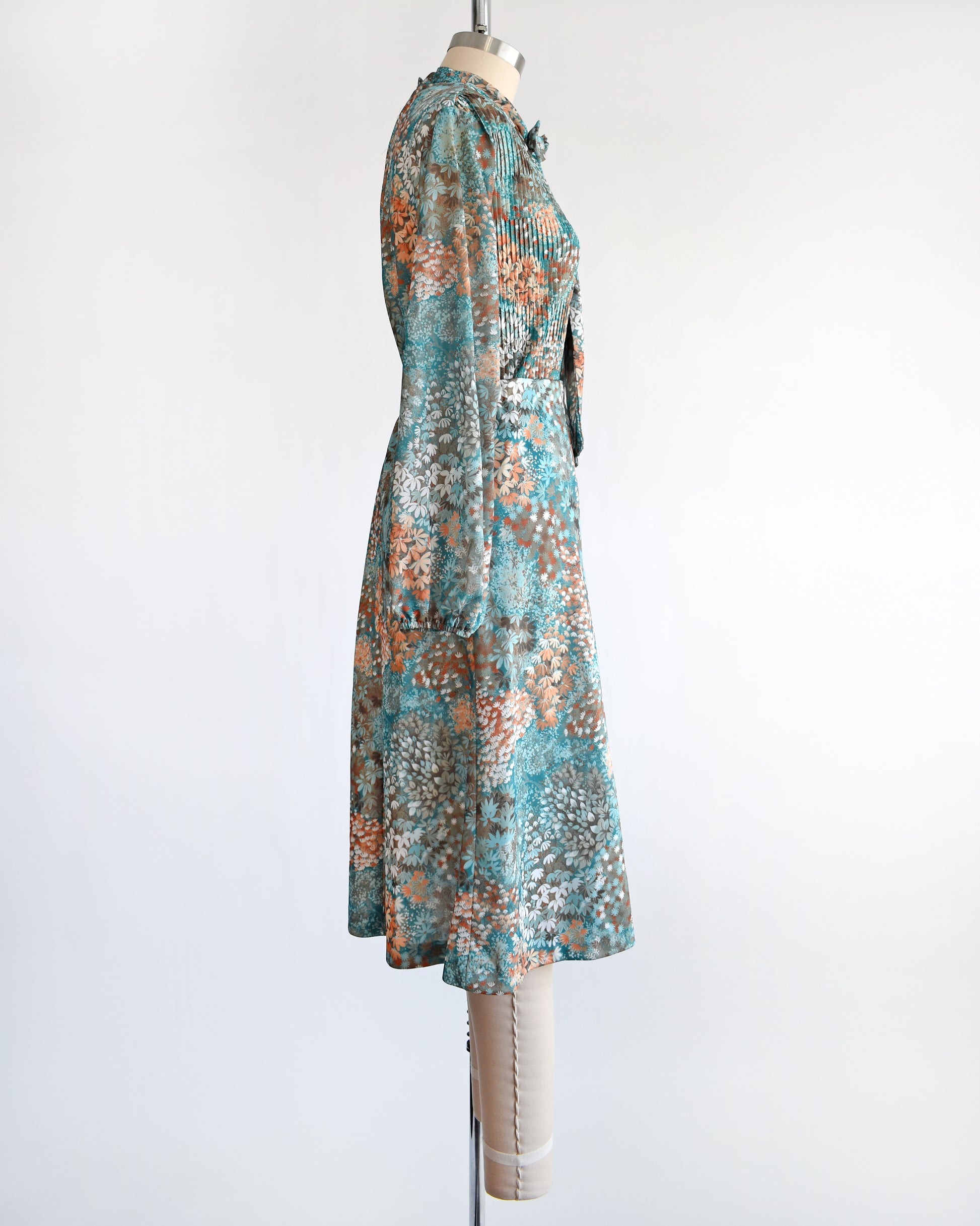 Side view of a vintage 1970s floral blue and orange floral dress set. This set comes with a matching blouse and skirt. 