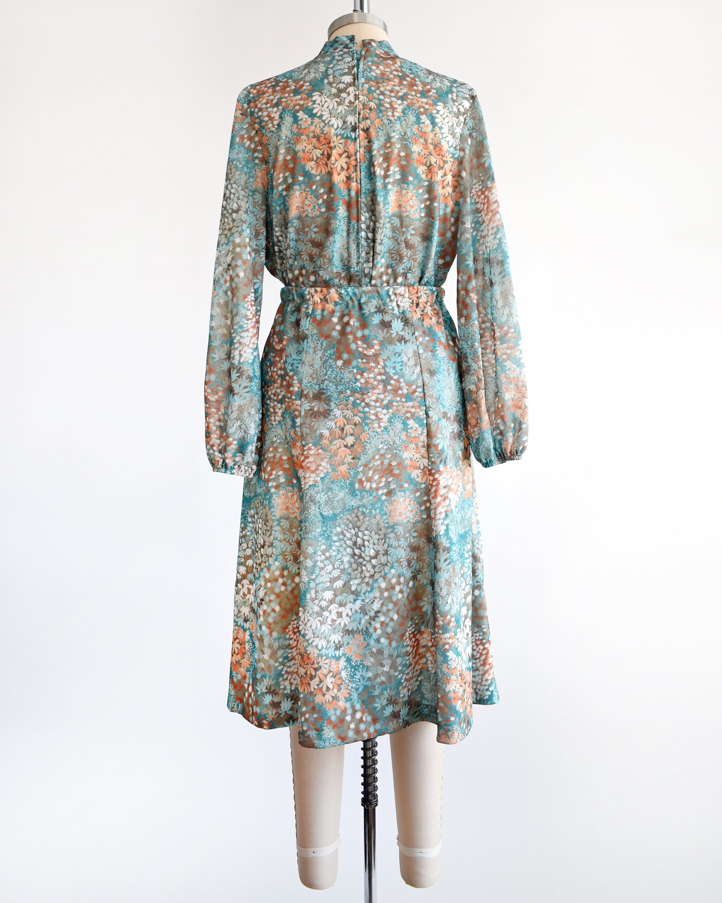 Back view of a vintage 1970s floral blue and orange floral dress set. This set comes with a matching blouse and skirt. 