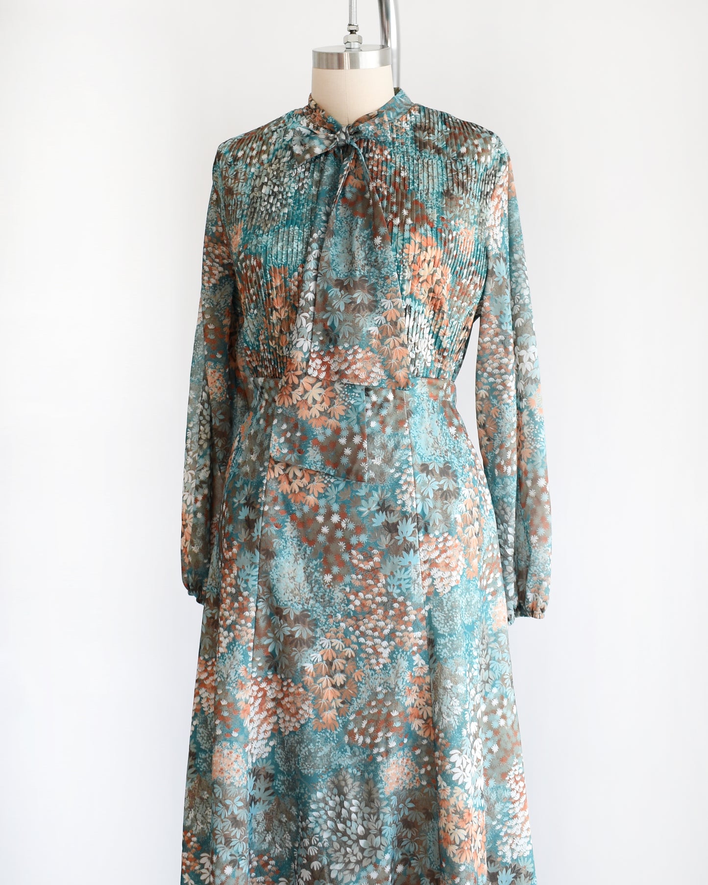Side front view of a vintage 1970s floral blue and orange floral dress set. This set comes with a matching blouse and skirt. 