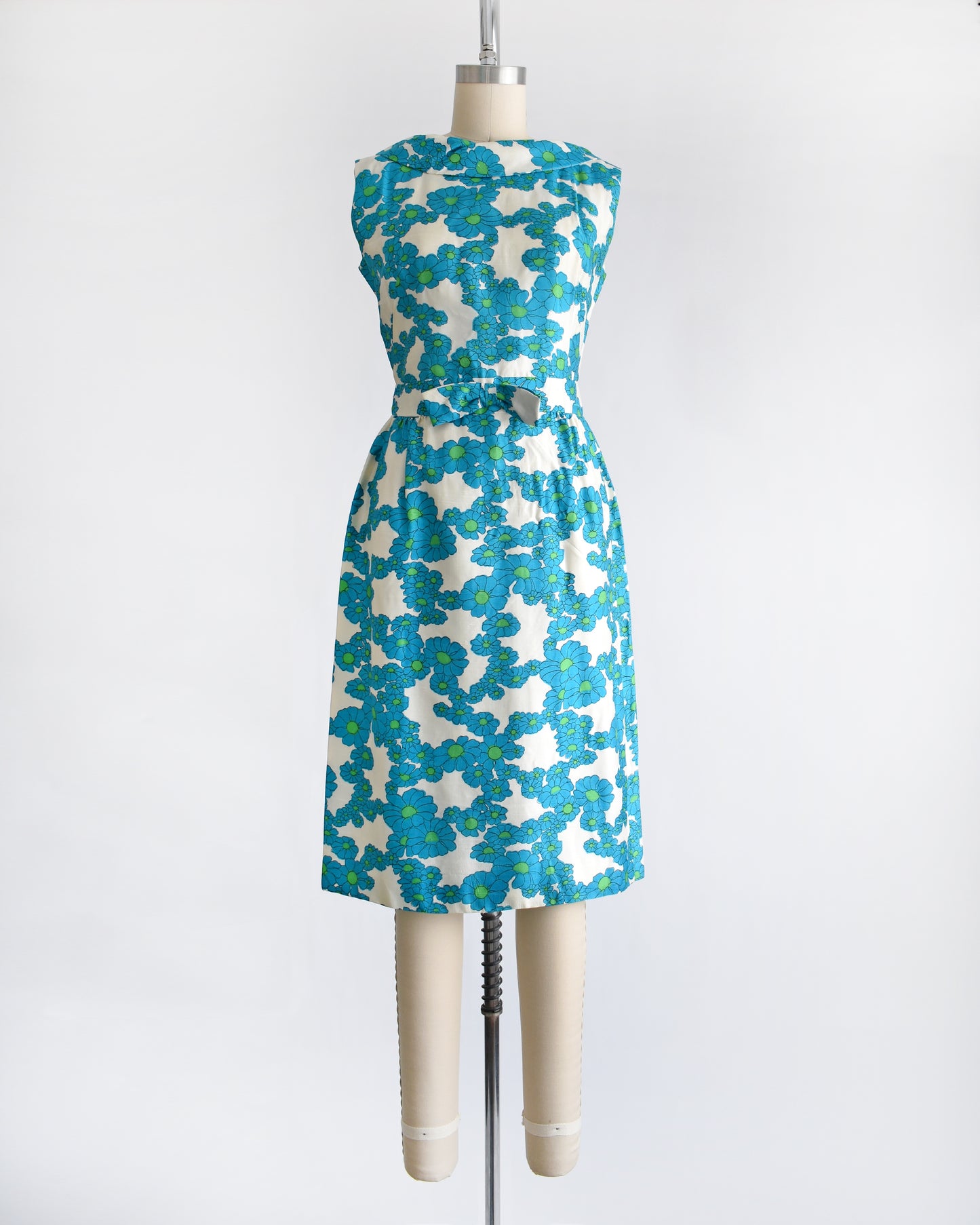 a vintage 1960s blue and white floral dress on a dress form