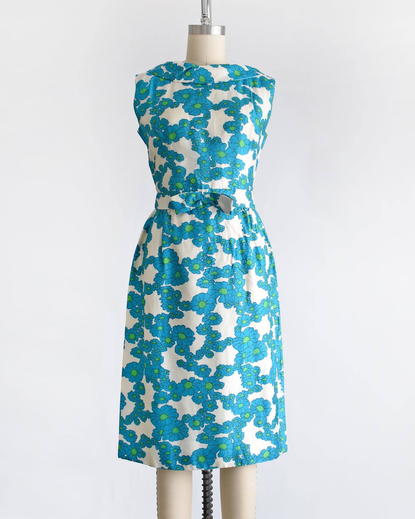a vintage 1960s blue and white floral dress on a dress form