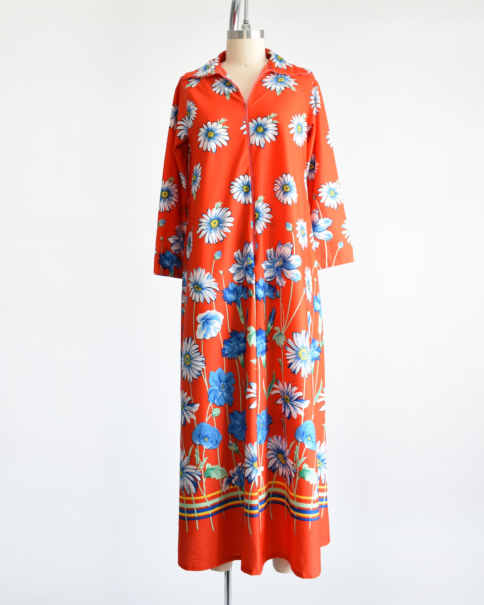 A vintage 1970s red floral lounge dress with a zipper down the front.  The zipper is zipped down a little bit in this photo